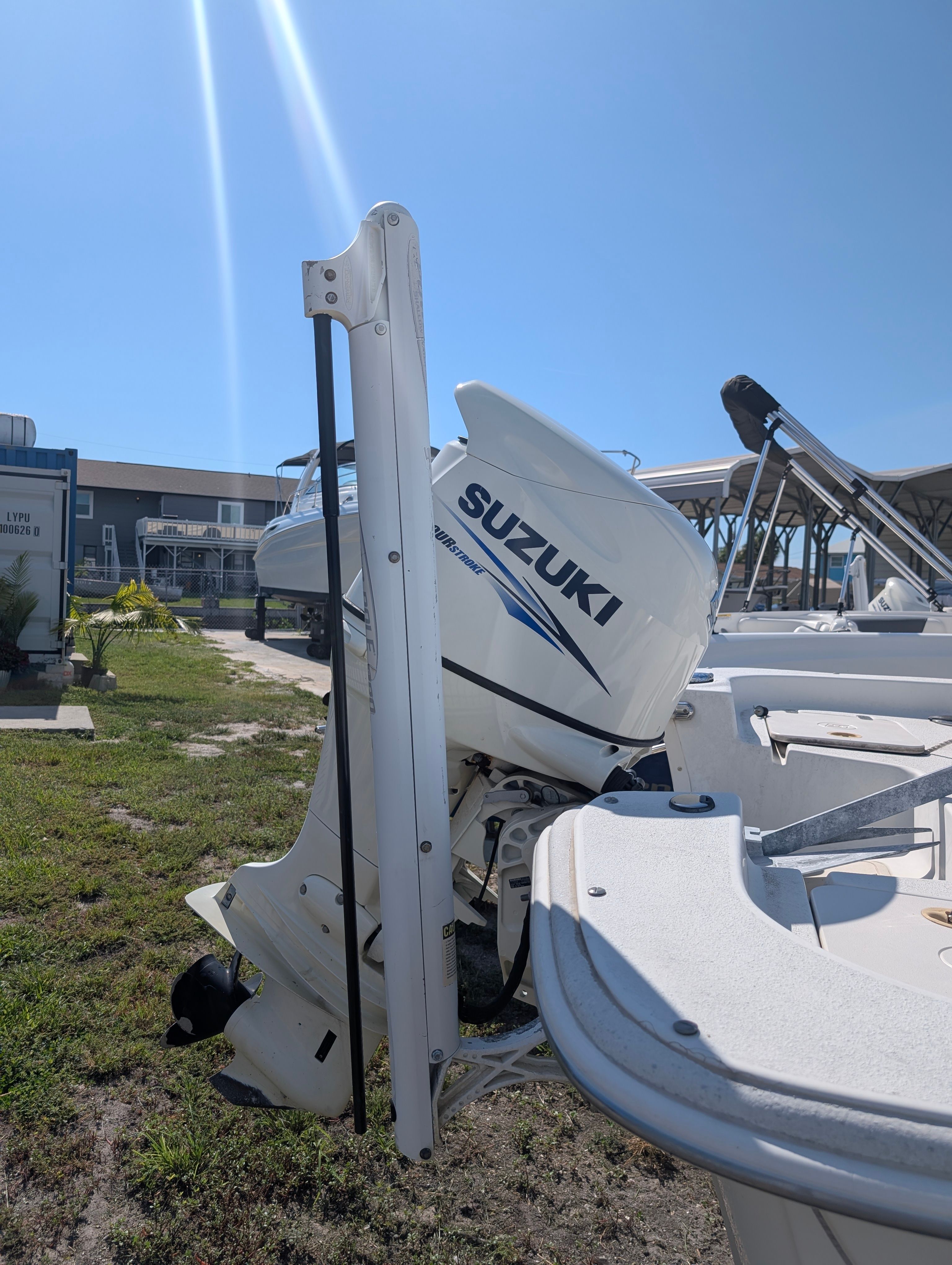 A 2016 Carolina Skiff 198 DLV with a Suzuki outboard motor, parked on grassy terrain.