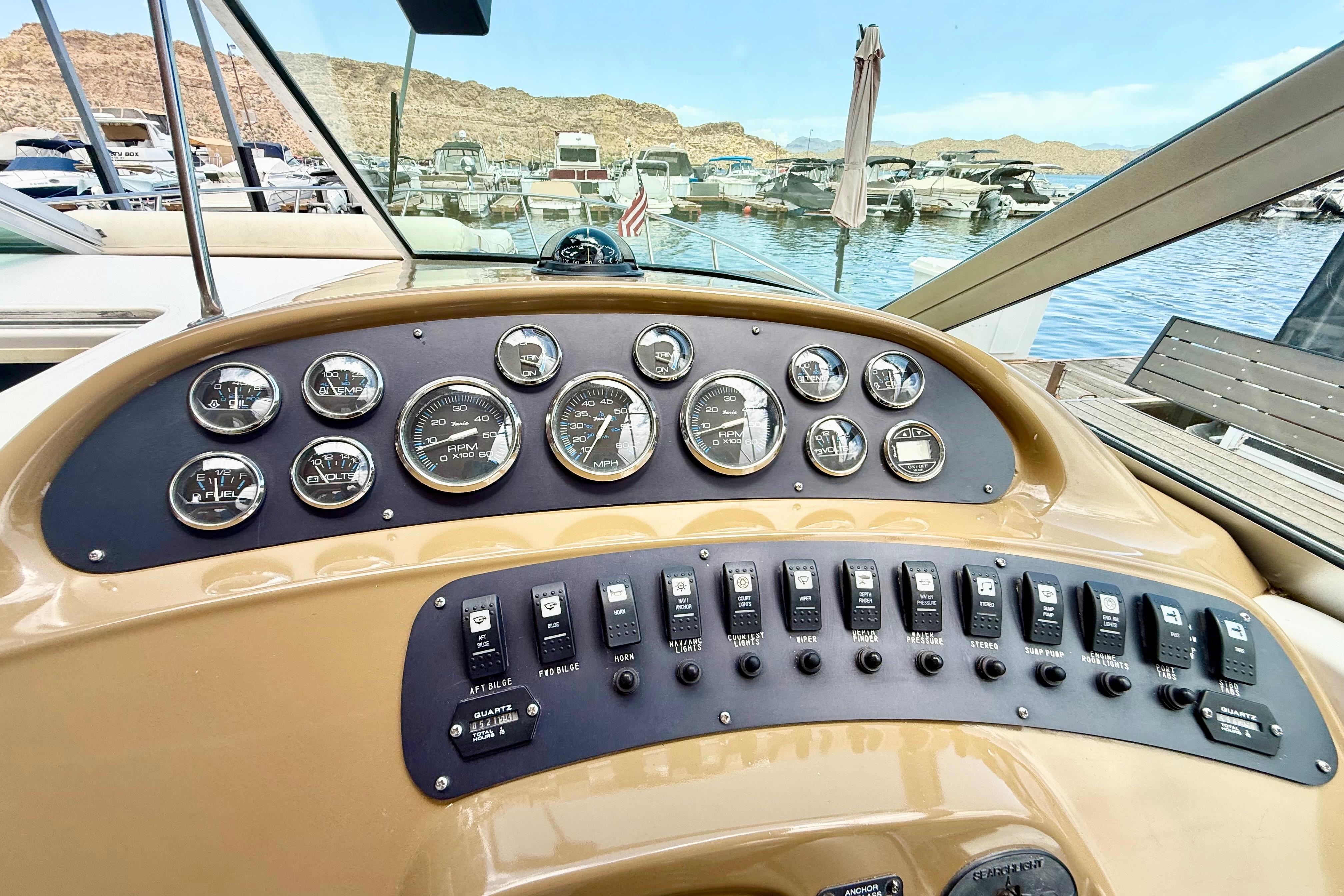 1999 Chaparral Signature 300 dashboard with gauges and switches, docked at a marina.
