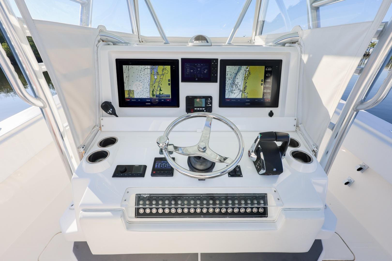 Control panel of 2016 Invincible 39 Open Fisherman boat with navigation screens and steering wheel.