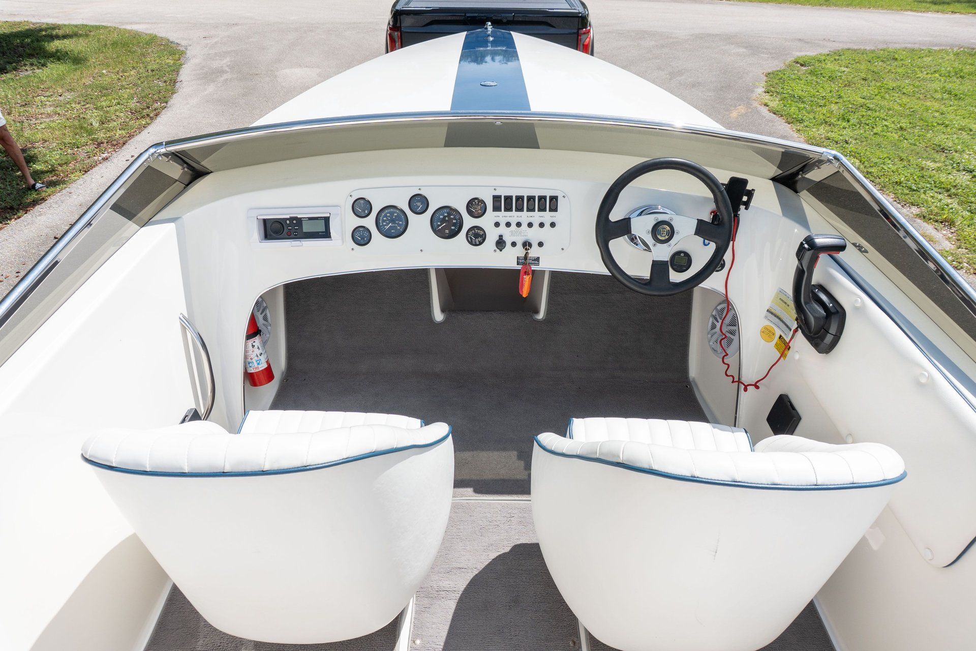 The cockpit of a 1995 Donzi 22 Classic boat with white seats and dashboard.
