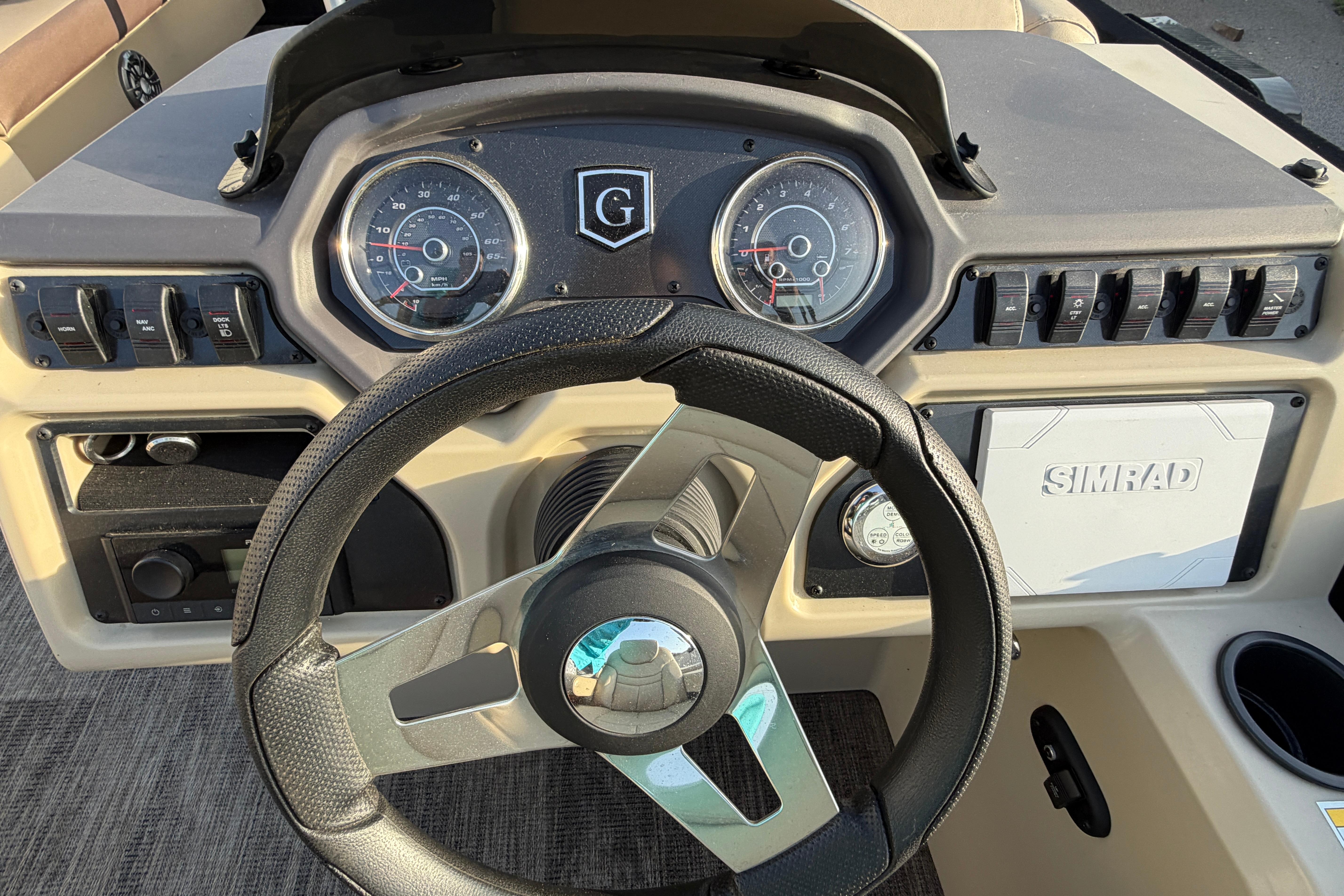 Steering console of 2023 Godfrey Sweetwater 2286 C boat with gauges and controls.
