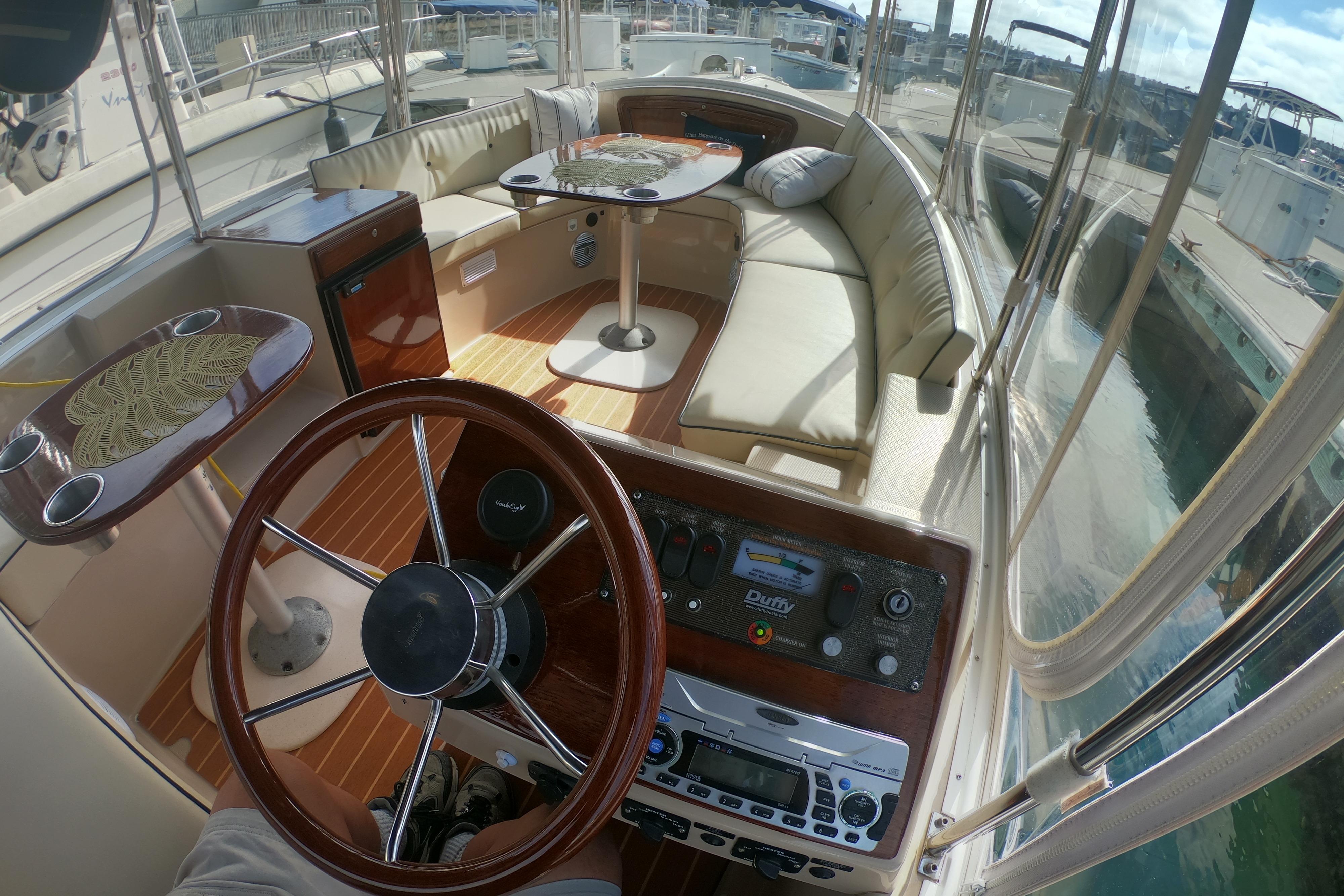 Interior of a 2008 Duffy Snug Harbor 18 boat with steering wheel and seating area.