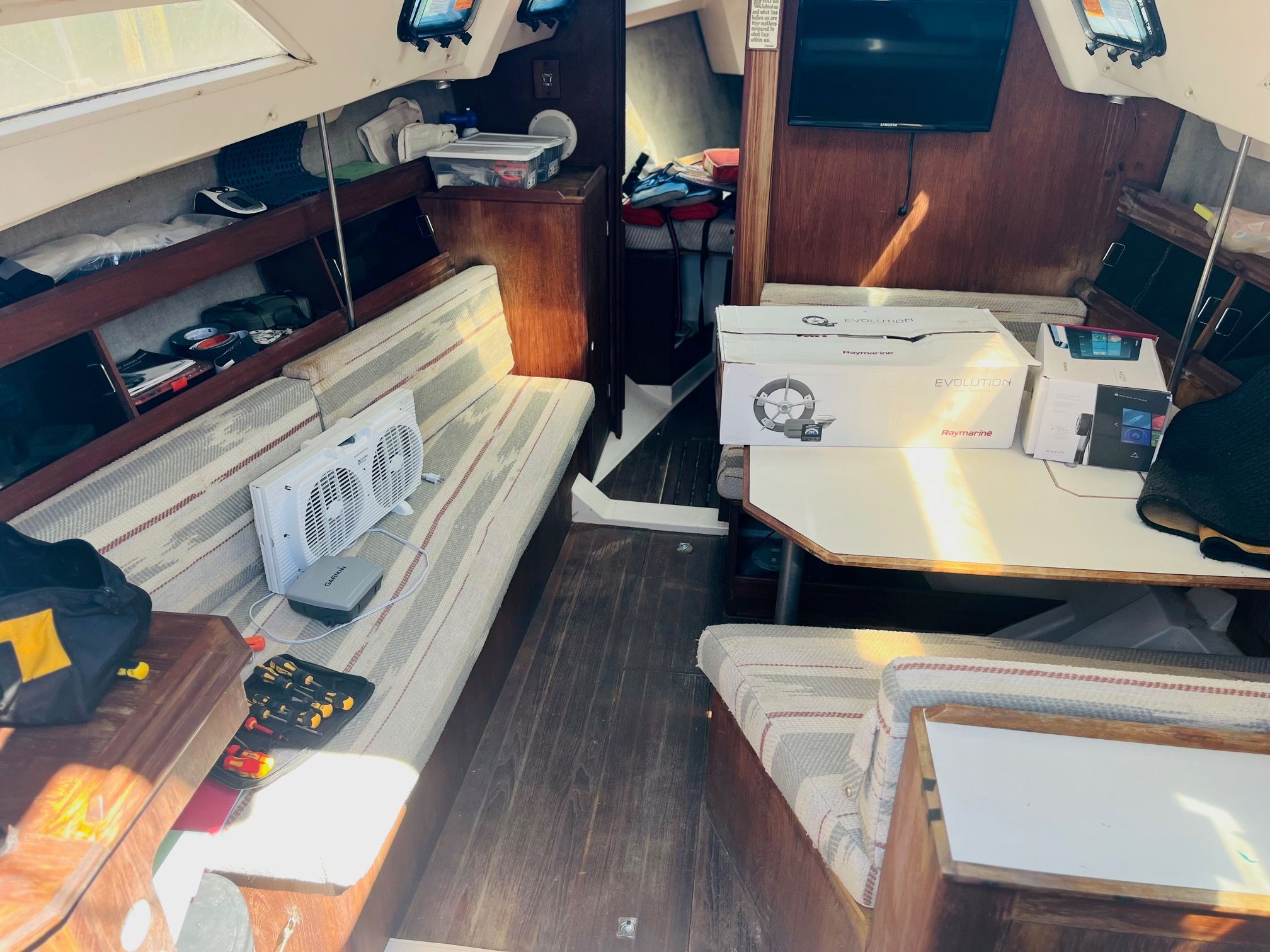 Interior of a 1985 Hunter 30 sailboat with cozy seating and wood finishes.