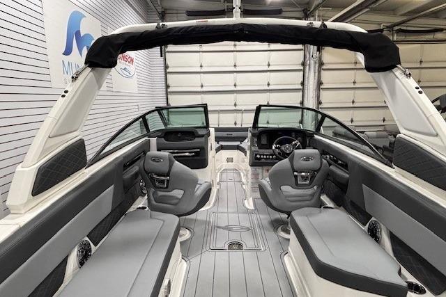 2026 Chaparral SSX 8 boat interior with sleek seating and modern dashboard in a showroom.