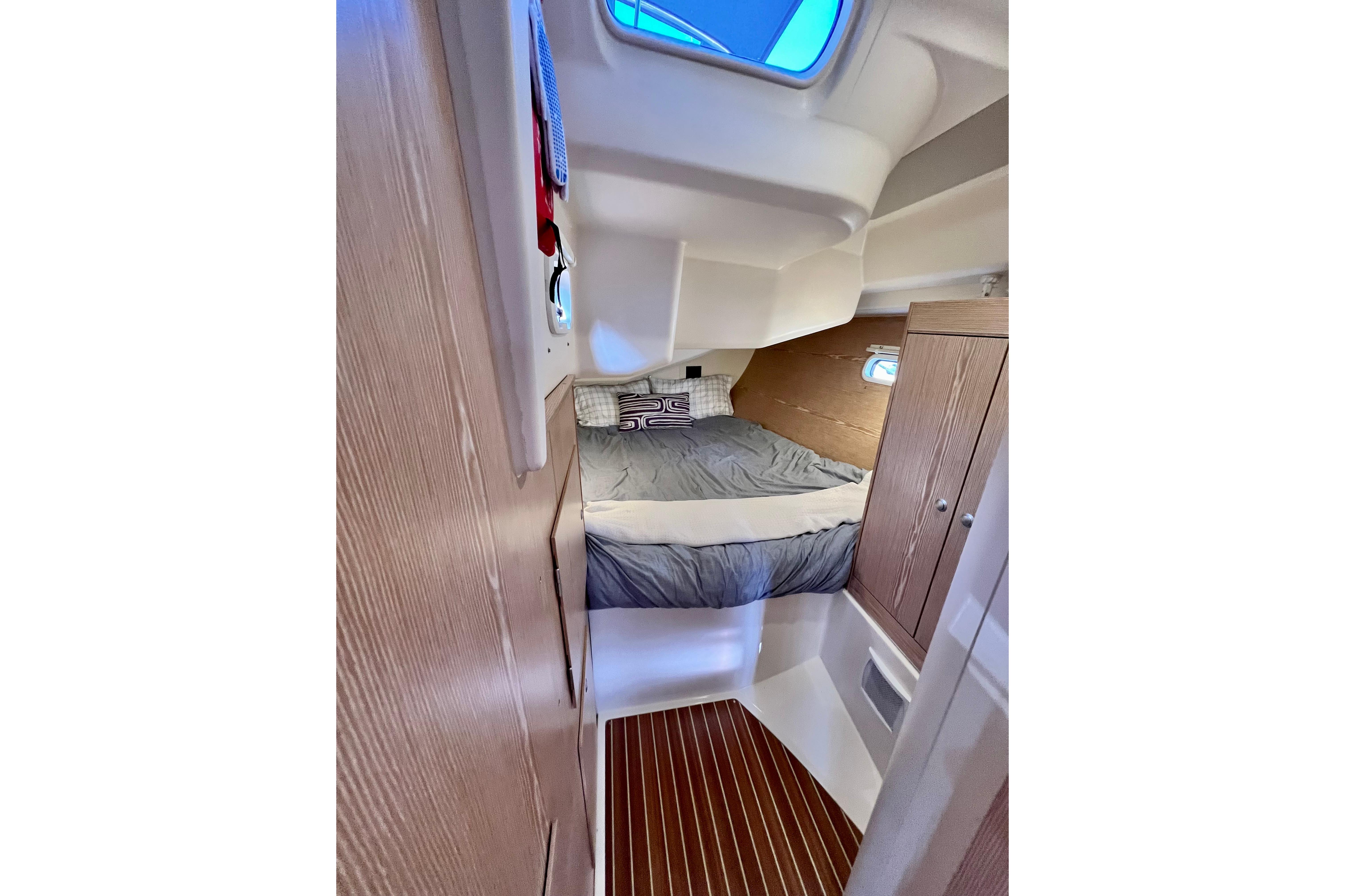 Cozy cabin interior of 2016 Hanse 455 yacht with bed and wooden cabinetry.