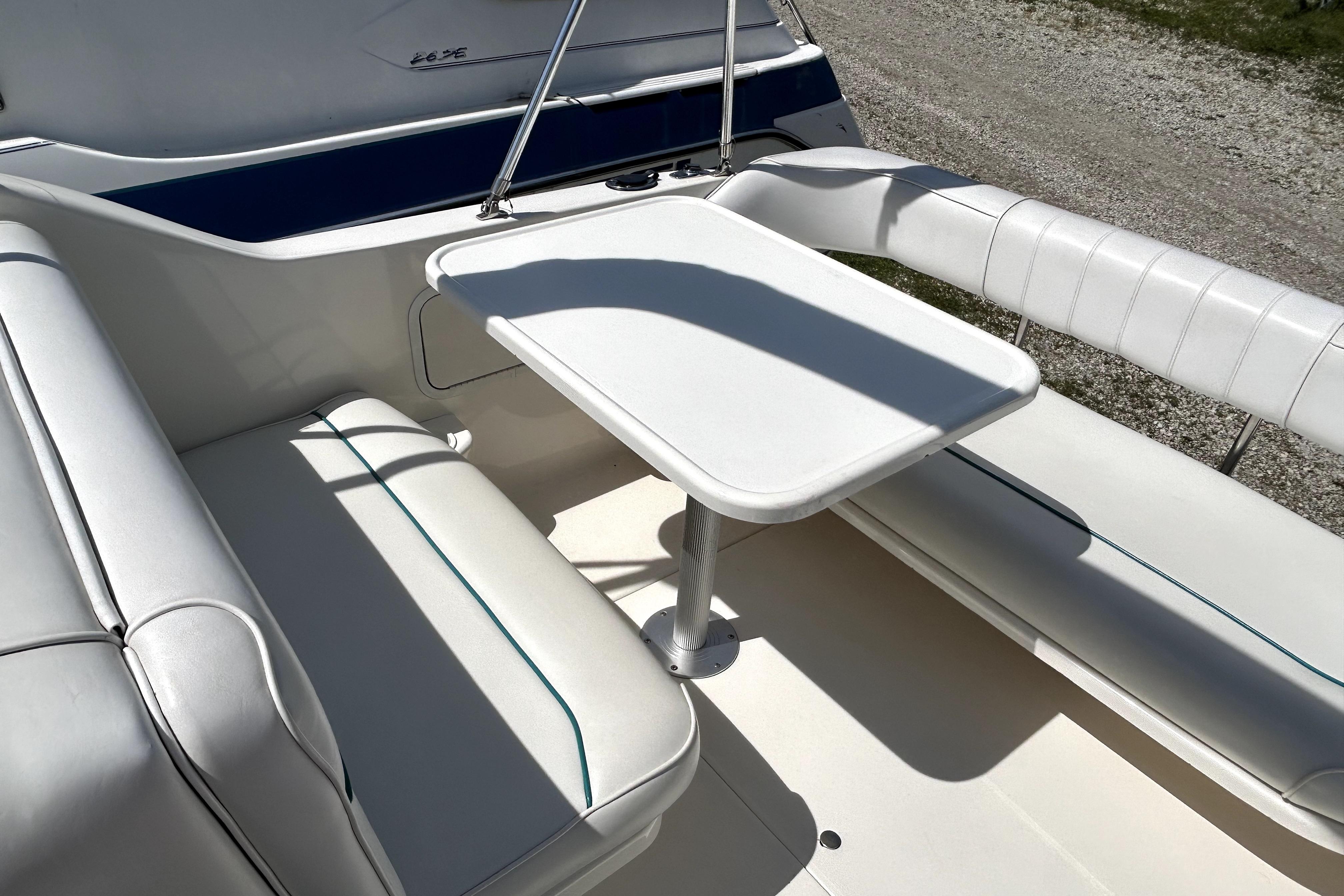 Interior seating area of a 1995 Sea Ray 250 Sundancer boat with white upholstery.