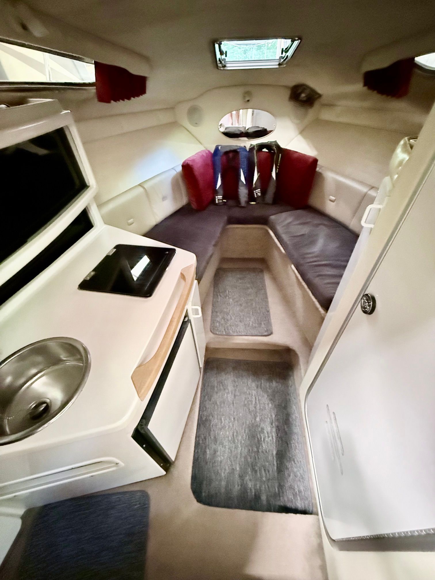 Interior of a 1997 Chaparral Signature 260 with seating area, sink, and storage.