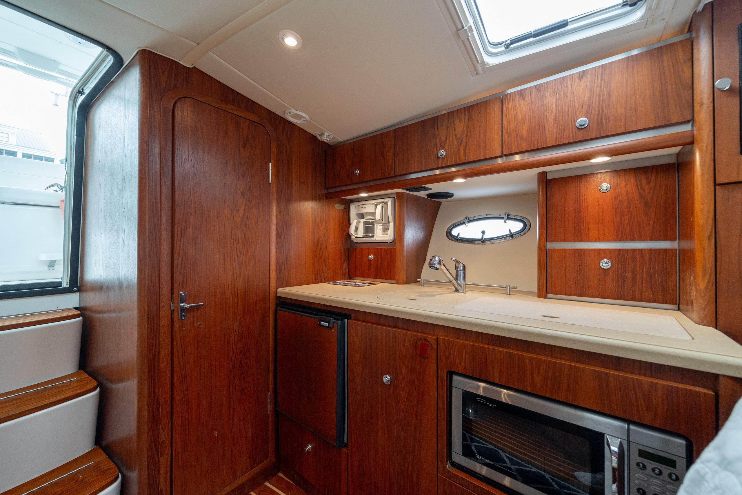 2004 Tiara Yachts 3200 Open interior with wood cabinetry and modern kitchen amenities.