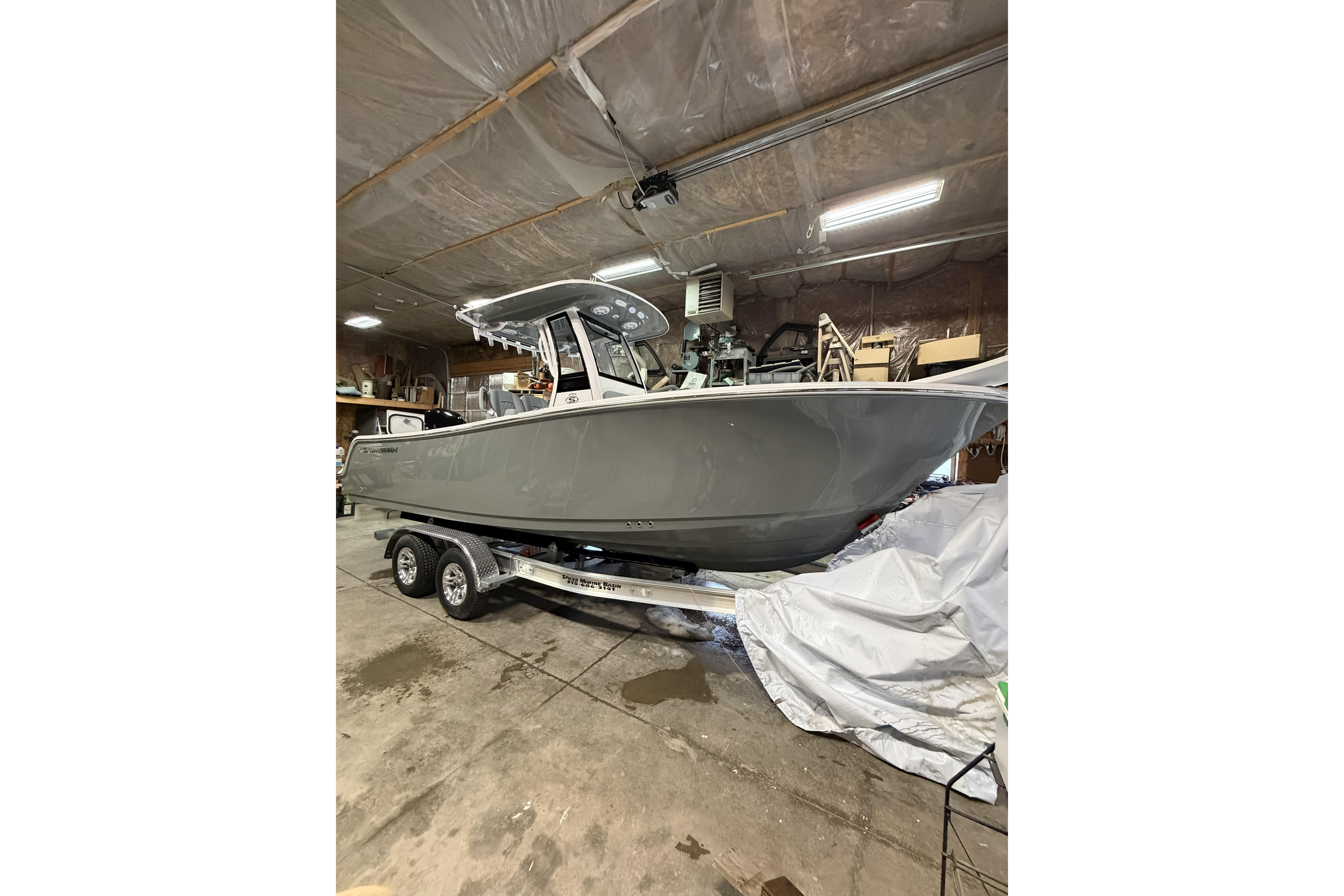 2026 Sportsman Open 232 Center Console boat on trailer in a garage.