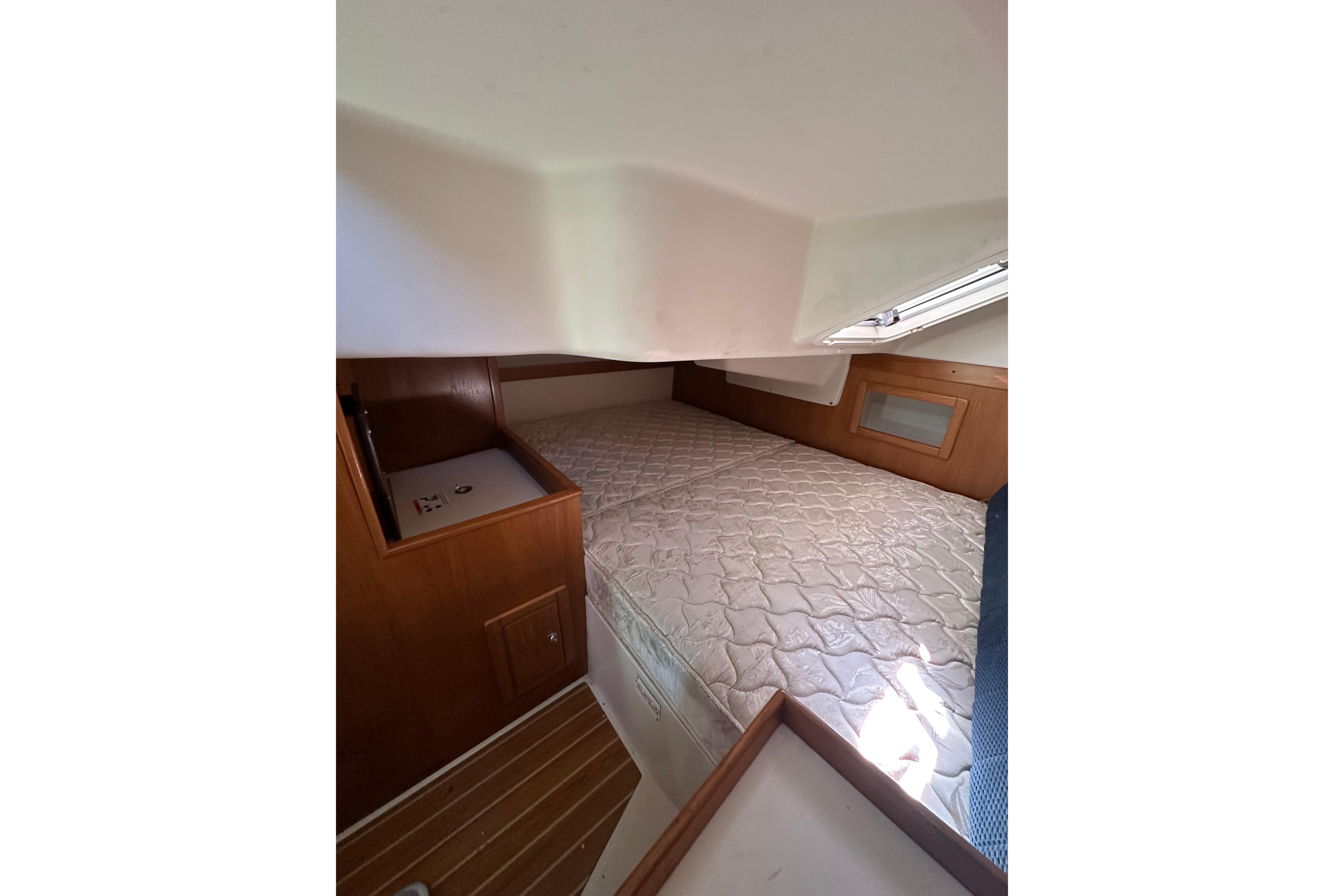 Interior cabin of 2004 Catalina 350 sailboat with bed and wooden cabinetry.