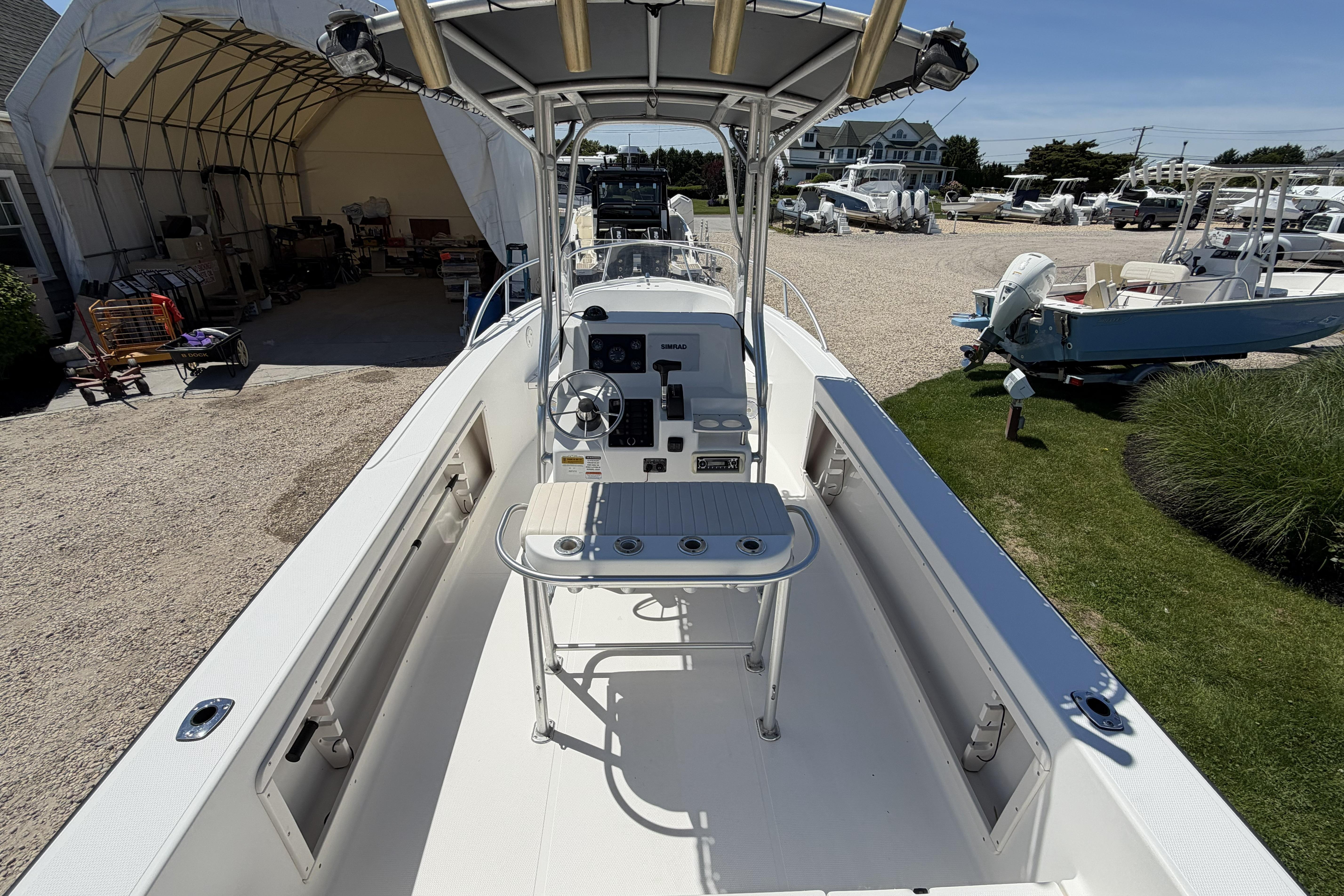 2006 Mako 212 Center Console boat with steering wheel and control panel, parked outdoors.