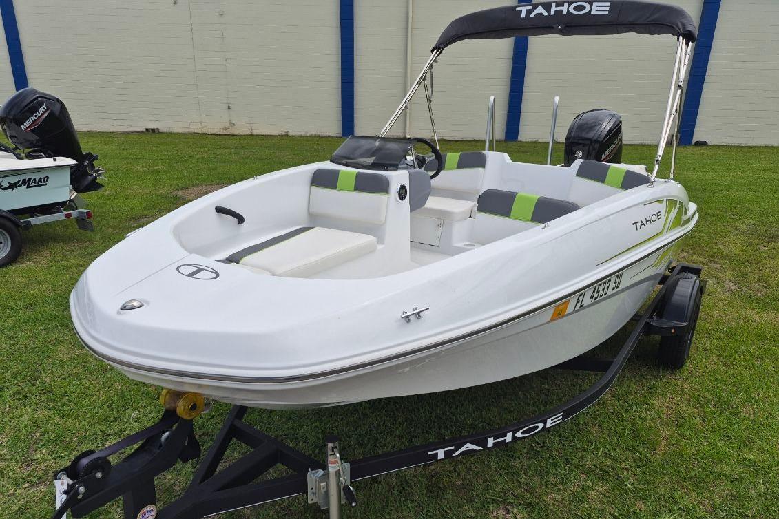 2021 Tahoe T16 boat on trailer, white with green accents, parked on grass.