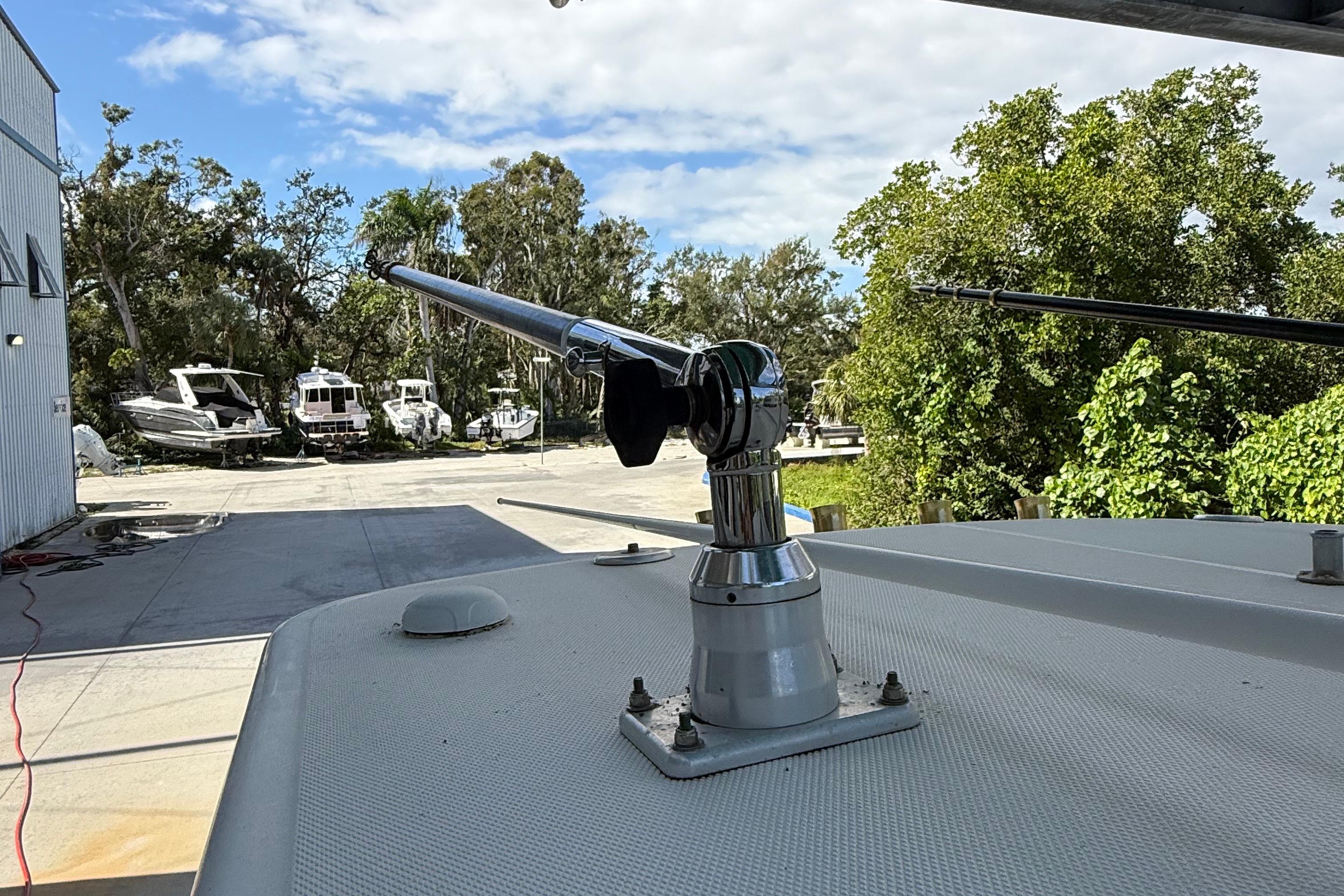 2008 Century 2901 Center Console boat with mounted fishing rod holder, docked near trees.