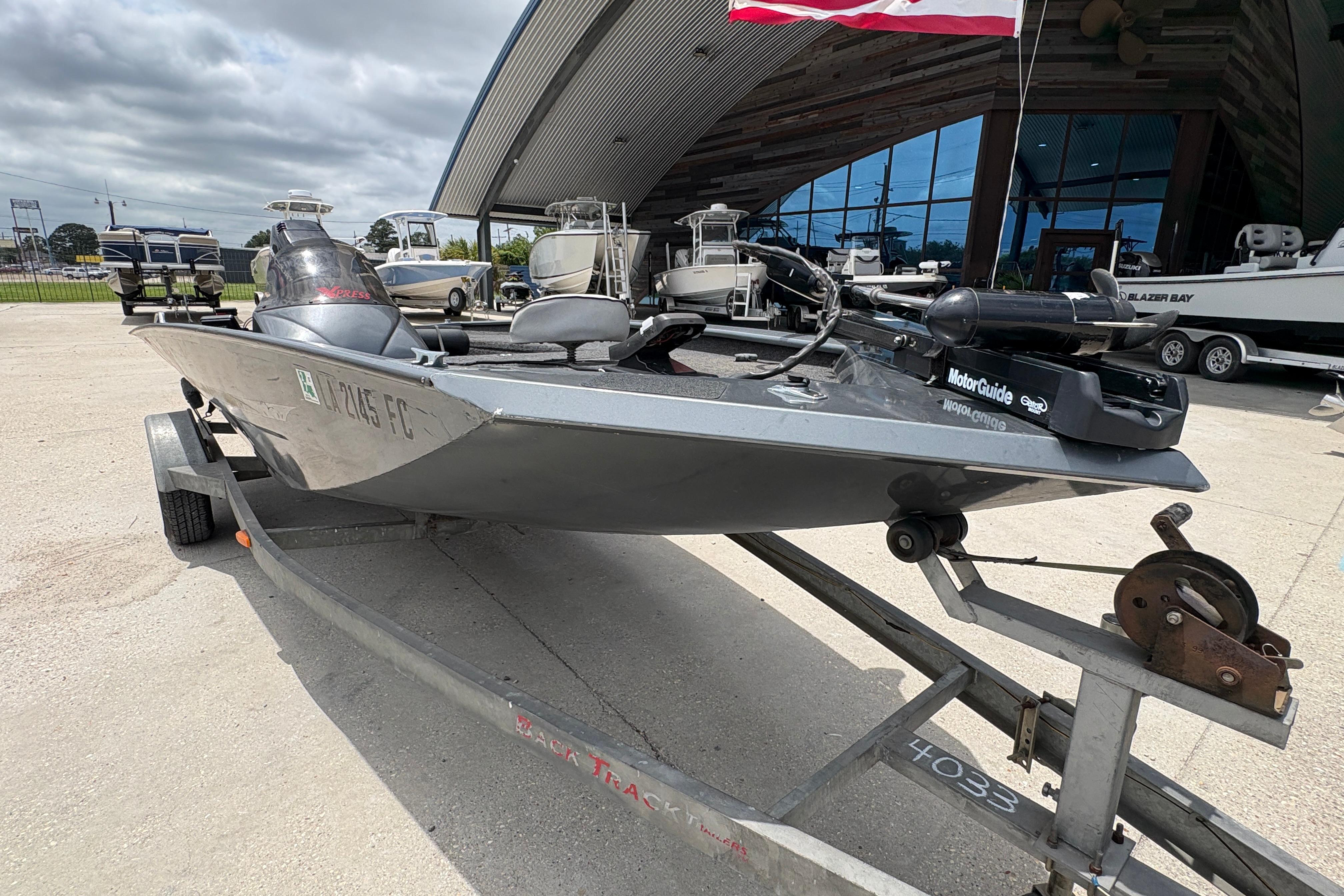 2000 Xpress X18 boat on trailer, parked outside a showroom.