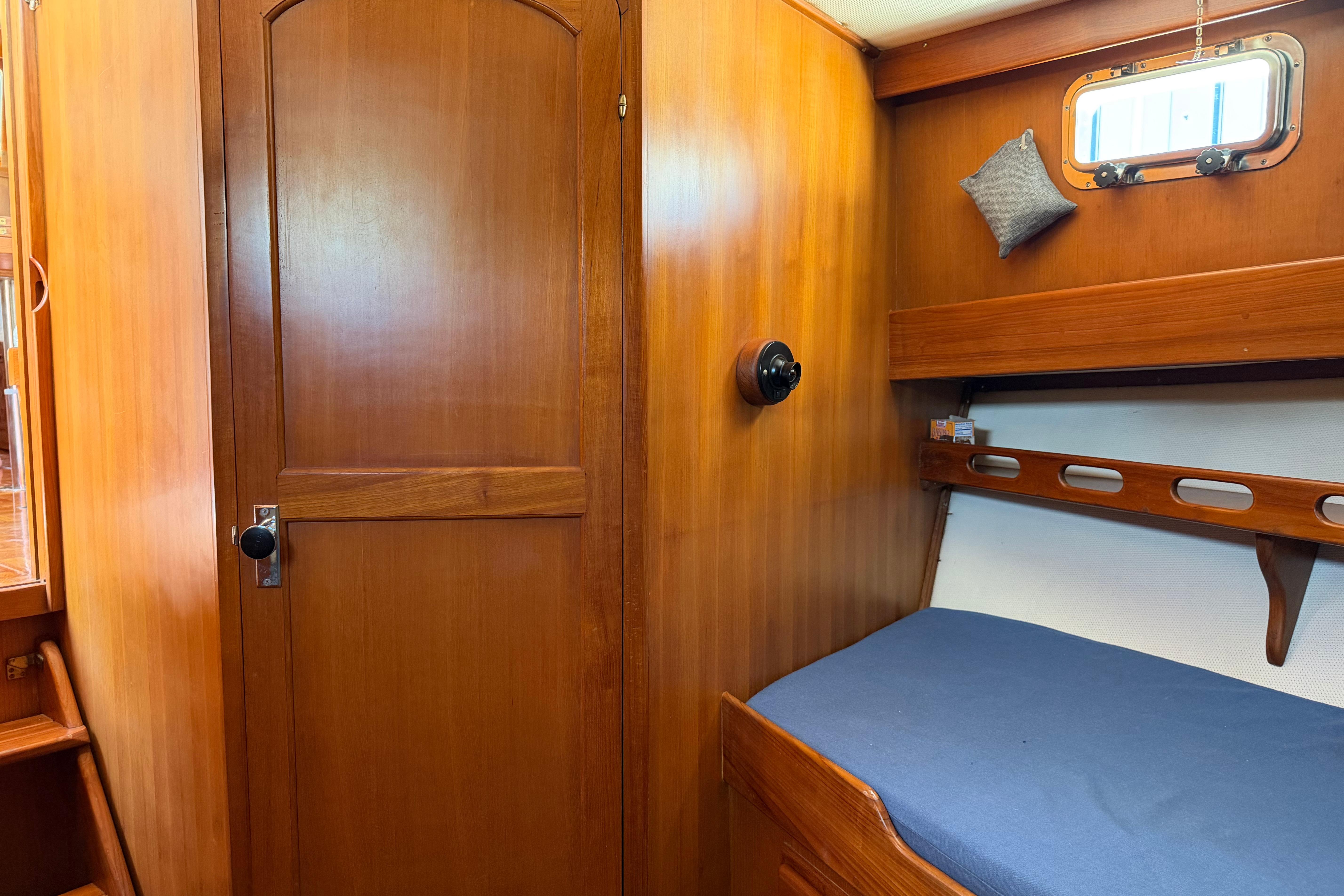 Cozy cabin interior of 1987 Marine Trader 36 with wooden door and bed.