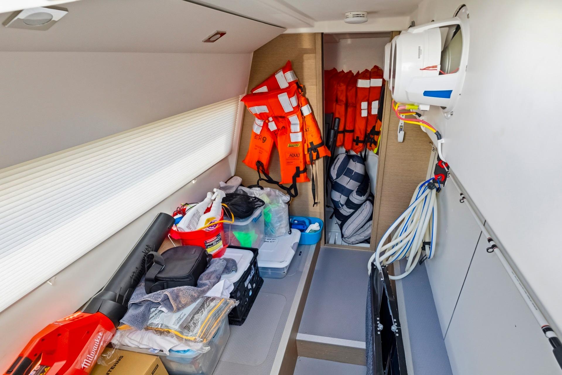 Storage area in a 2022 Prestige 520 yacht with life jackets and equipment.
