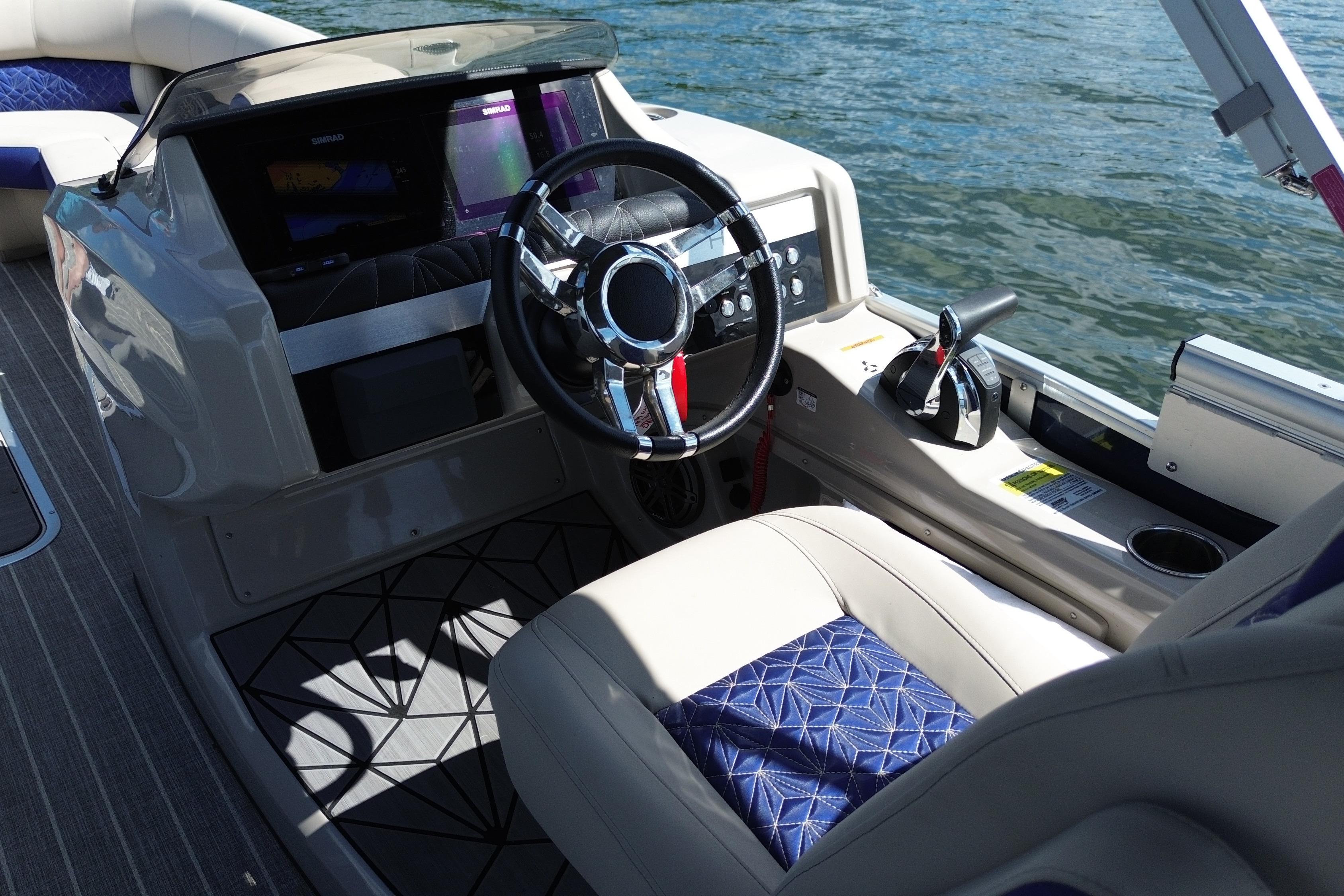Interior of 2022 Harris Grand Mariner 250 boat with steering wheel and control panel.