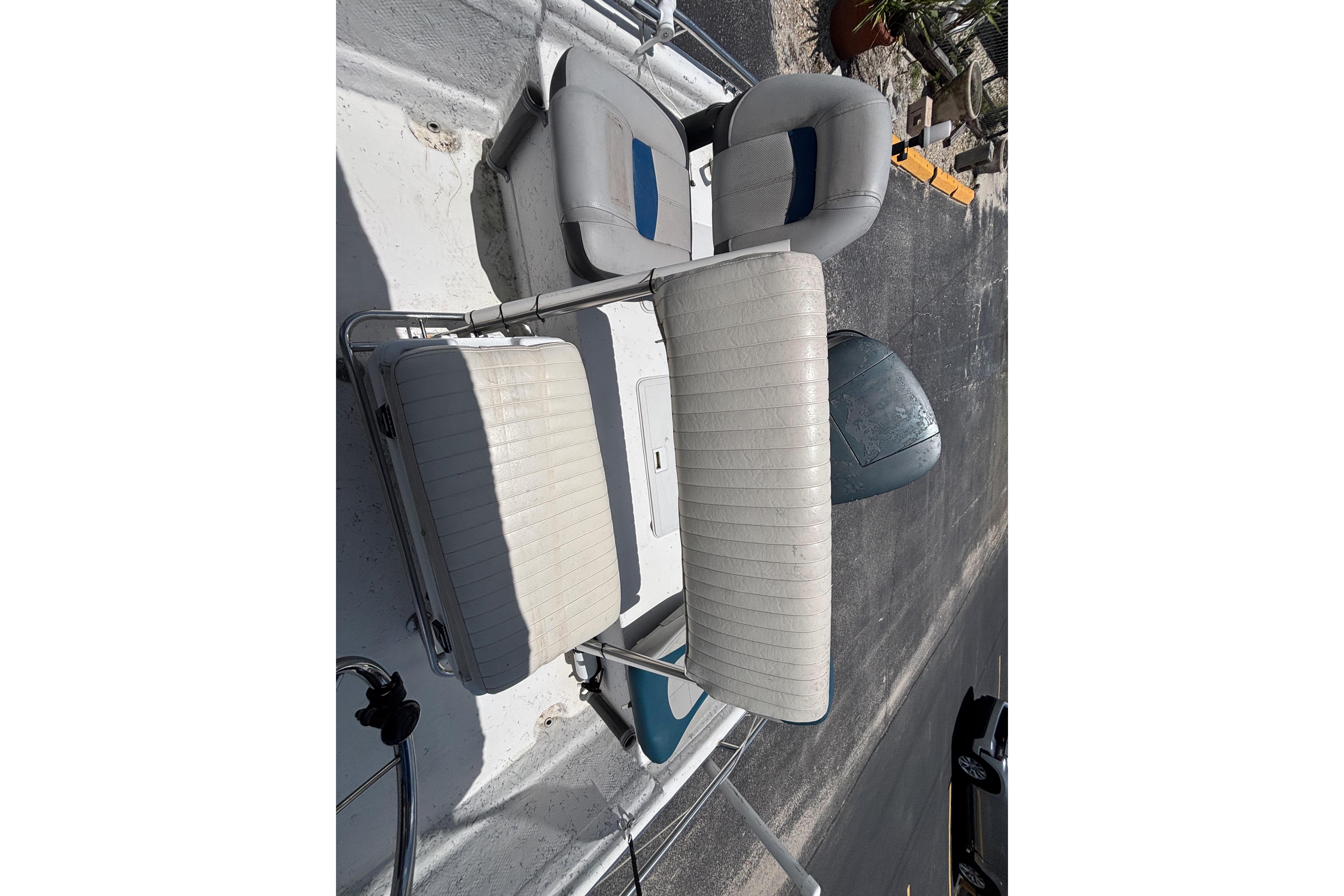 Boat seating on a 2000 VIP 1880 BAY STEALTH, featuring white and blue cushioned chairs.