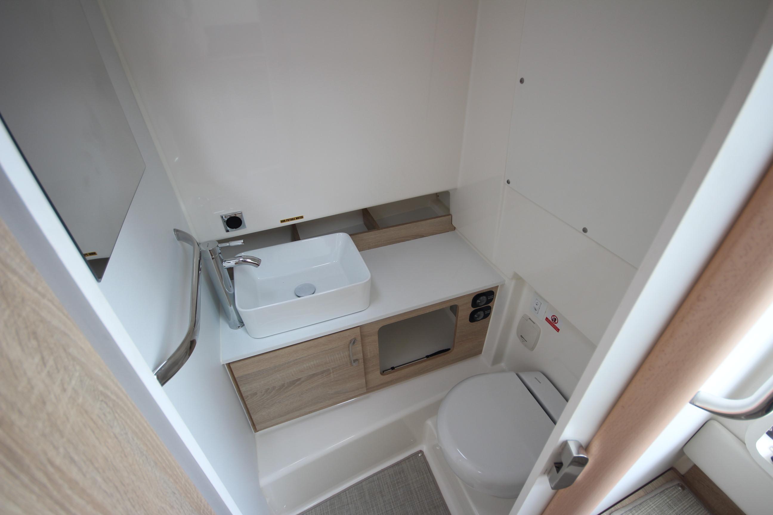 Modern bathroom in 2025 Zodiac X10CC boat, featuring sleek sink and compact toilet design.