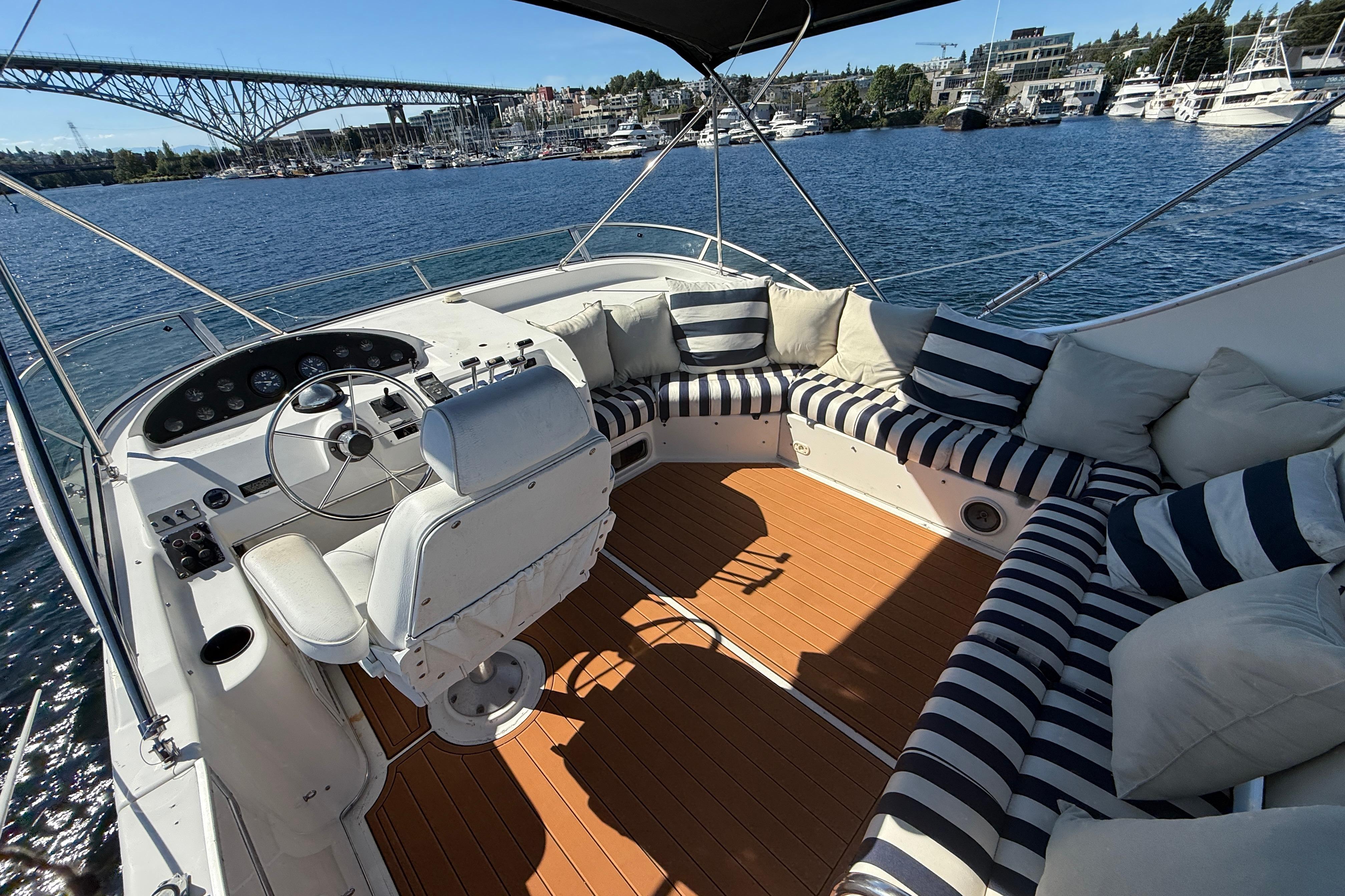 1997 Bayliner 3988 Command Bridge Motoryacht with striped seating, overlooking marina and bridge.