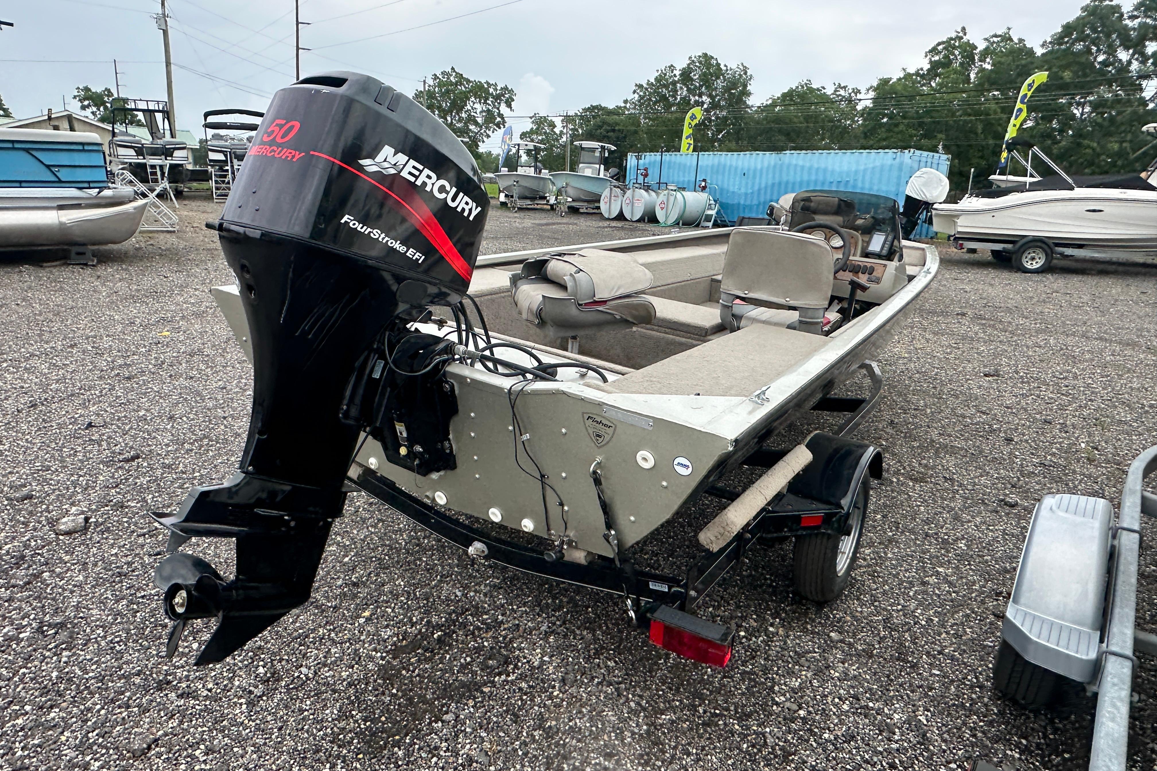 2002 Fisher 1710 boat with Mercury 50 FourStroke EFI engine on gravel lot.