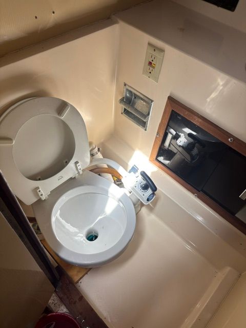A small boat bathroom with a toilet and a mirror.
