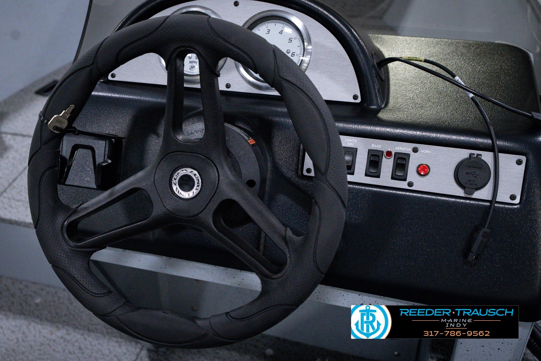 Steering wheel and dashboard of 2026 Lund 1600 Fury SS boat with control switches.