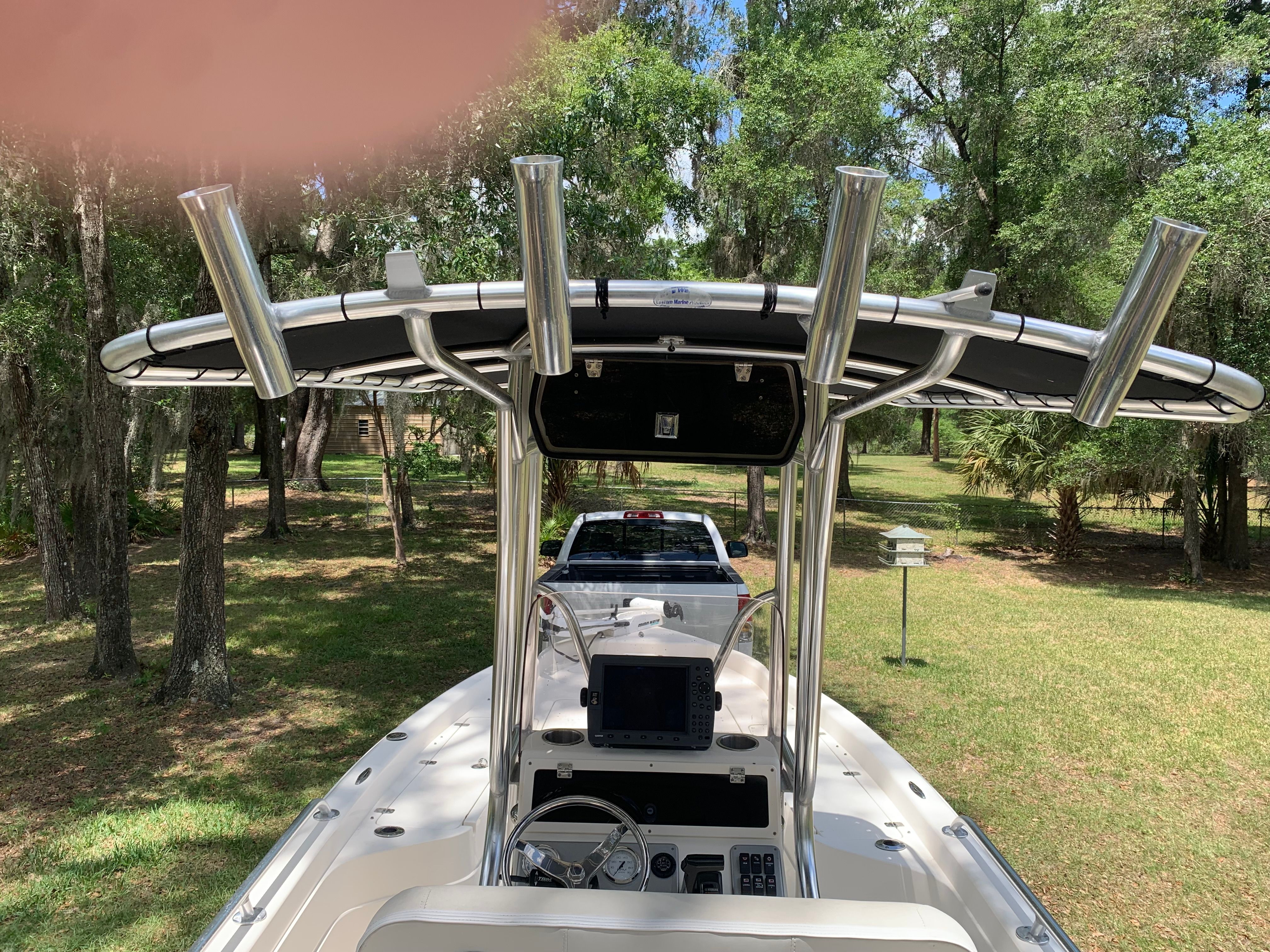 2007 ShearWater 23 LTZ boat with T-top parked in wooded area.