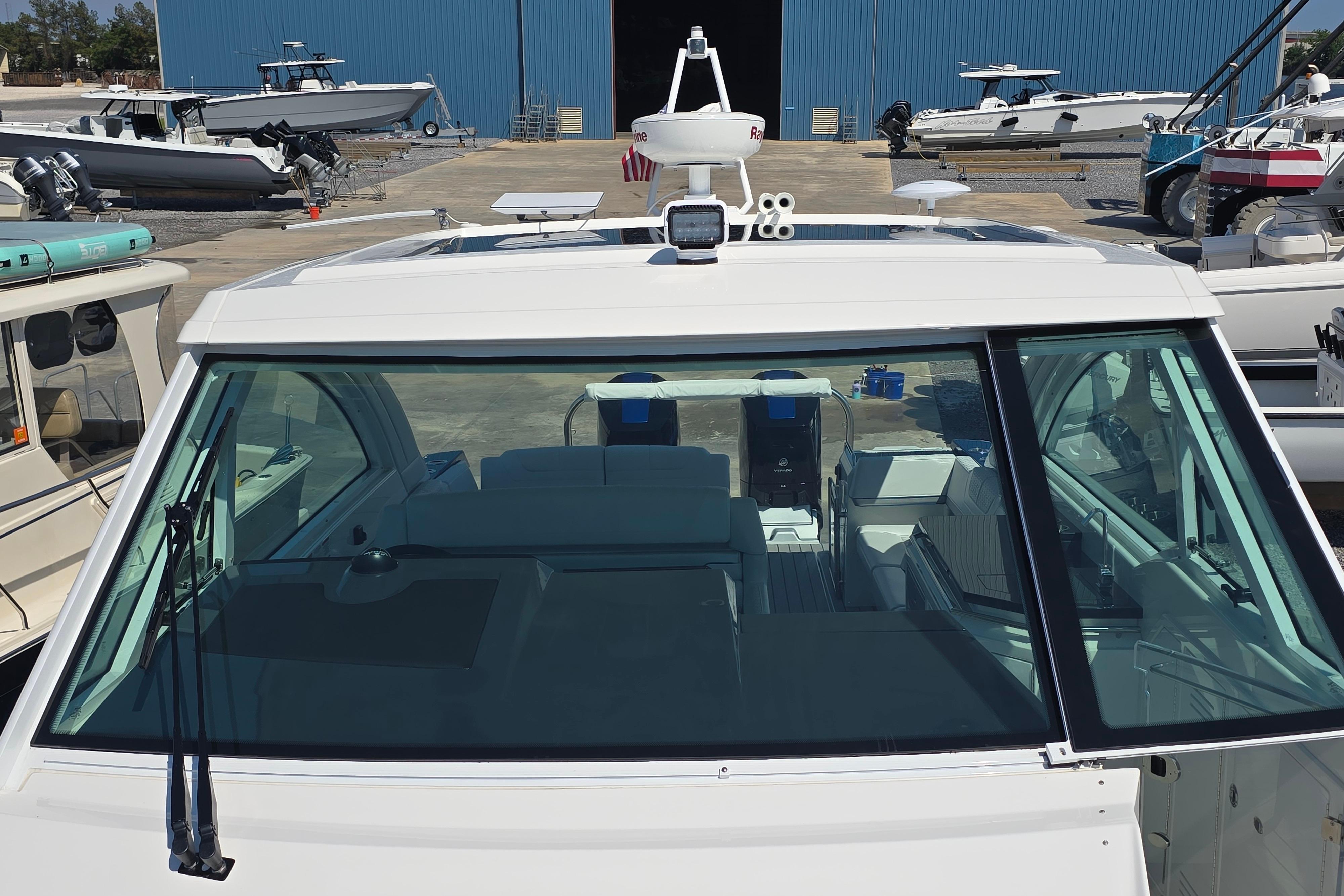 2025 Formula 380 Super Sport Crossover OB boat at a marina, front view.
