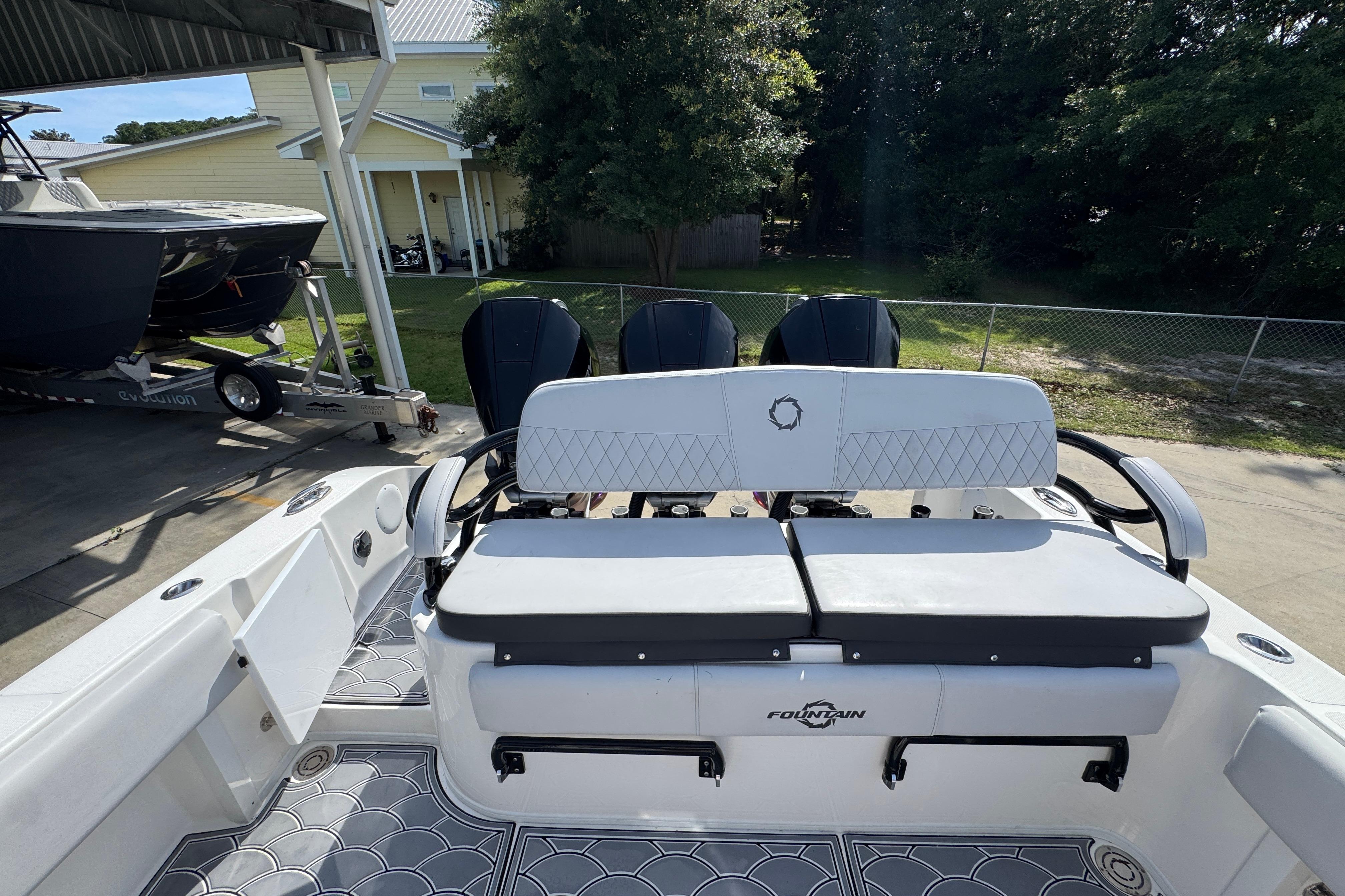 2023 Fountain 34 Tournament Edition boat with cushioned seating and triple outboard motors.