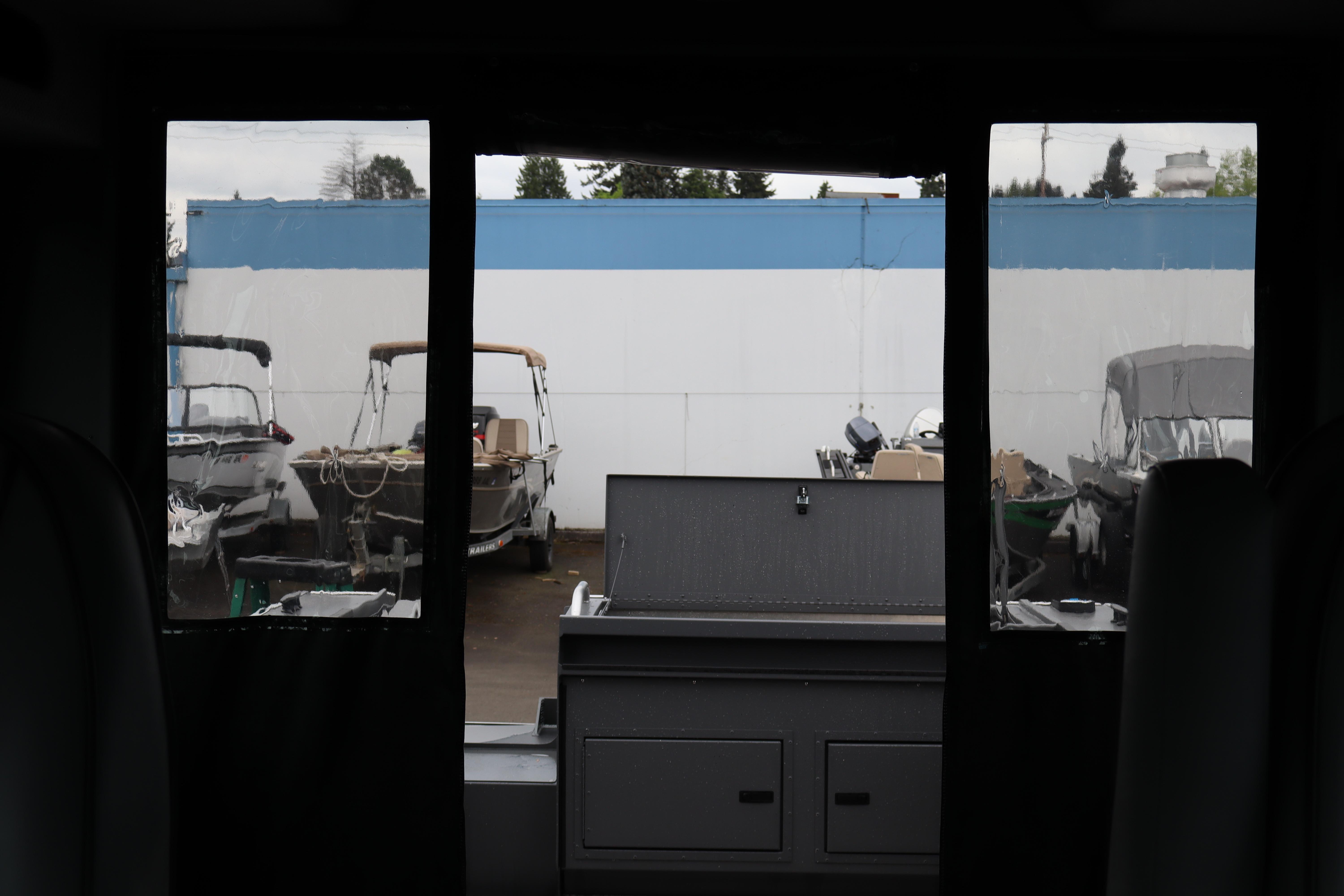Interior view of 2026 Alumaweld Horizon 24 boat, showcasing docked vessels outside.