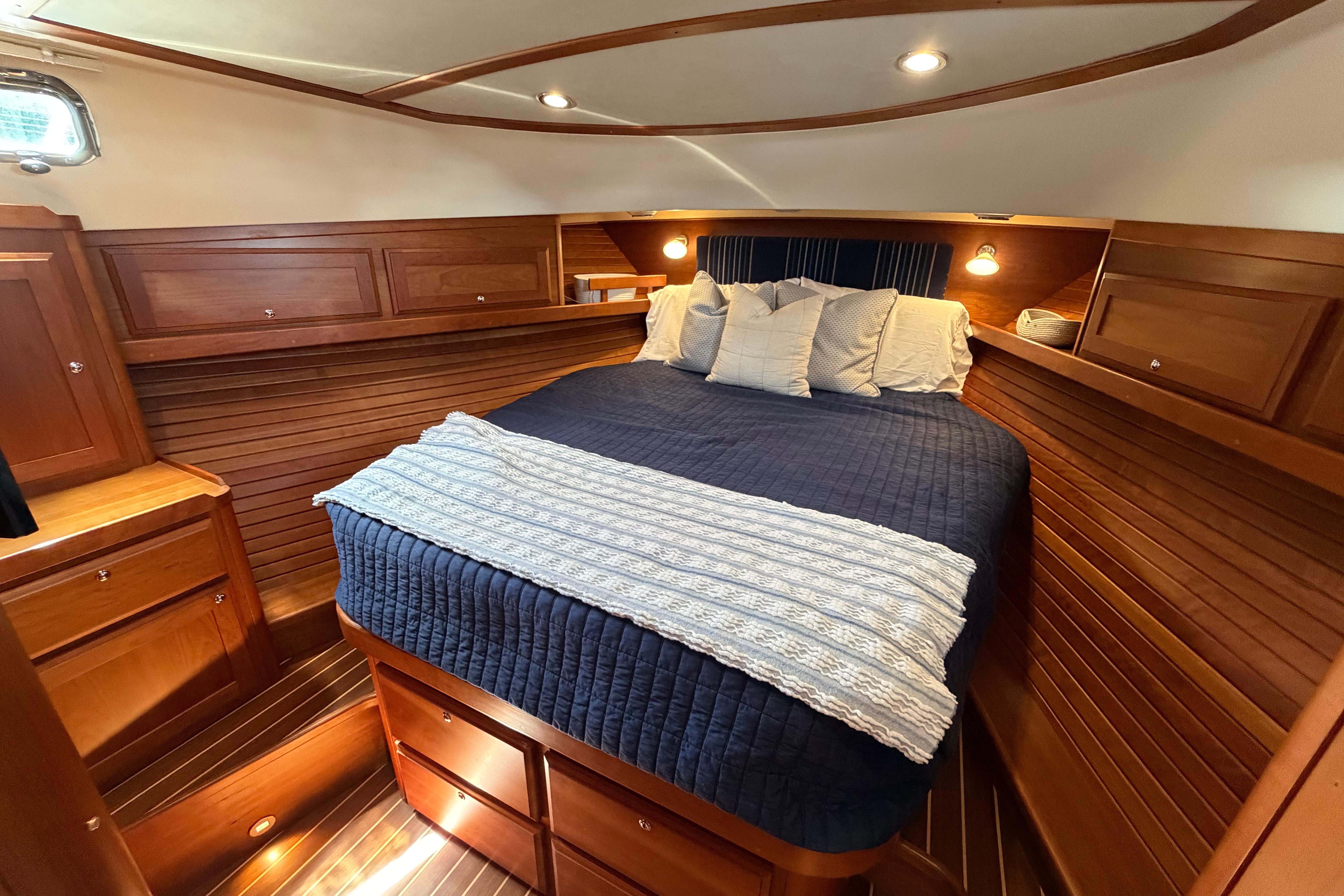 Luxurious cabin interior of 2015 Sabre 38 Salon Express with cozy bedding and wooden finish.