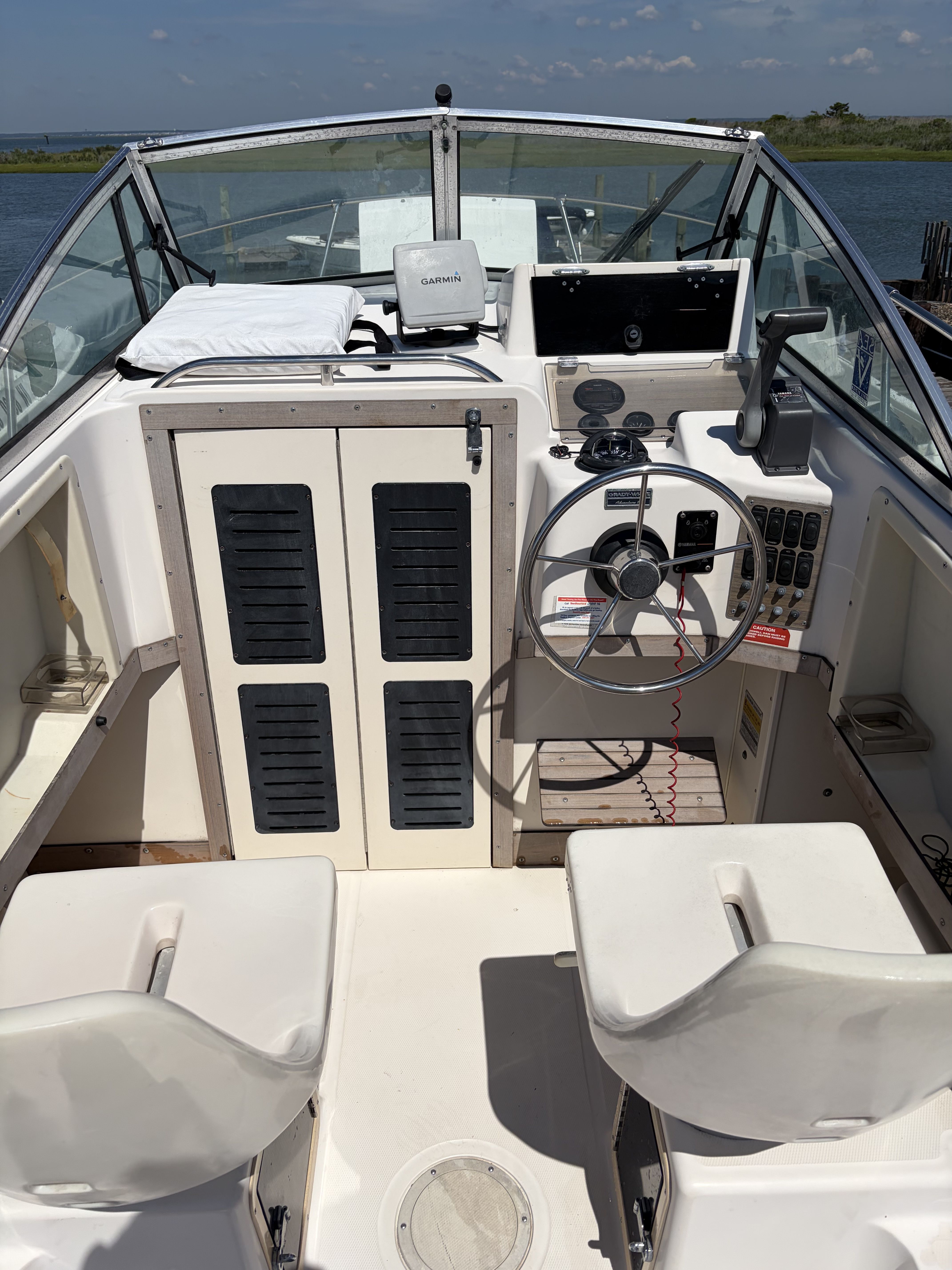 The cockpit of a 1993 Grady-White Adventure 208 with two seats and a steering wheel.