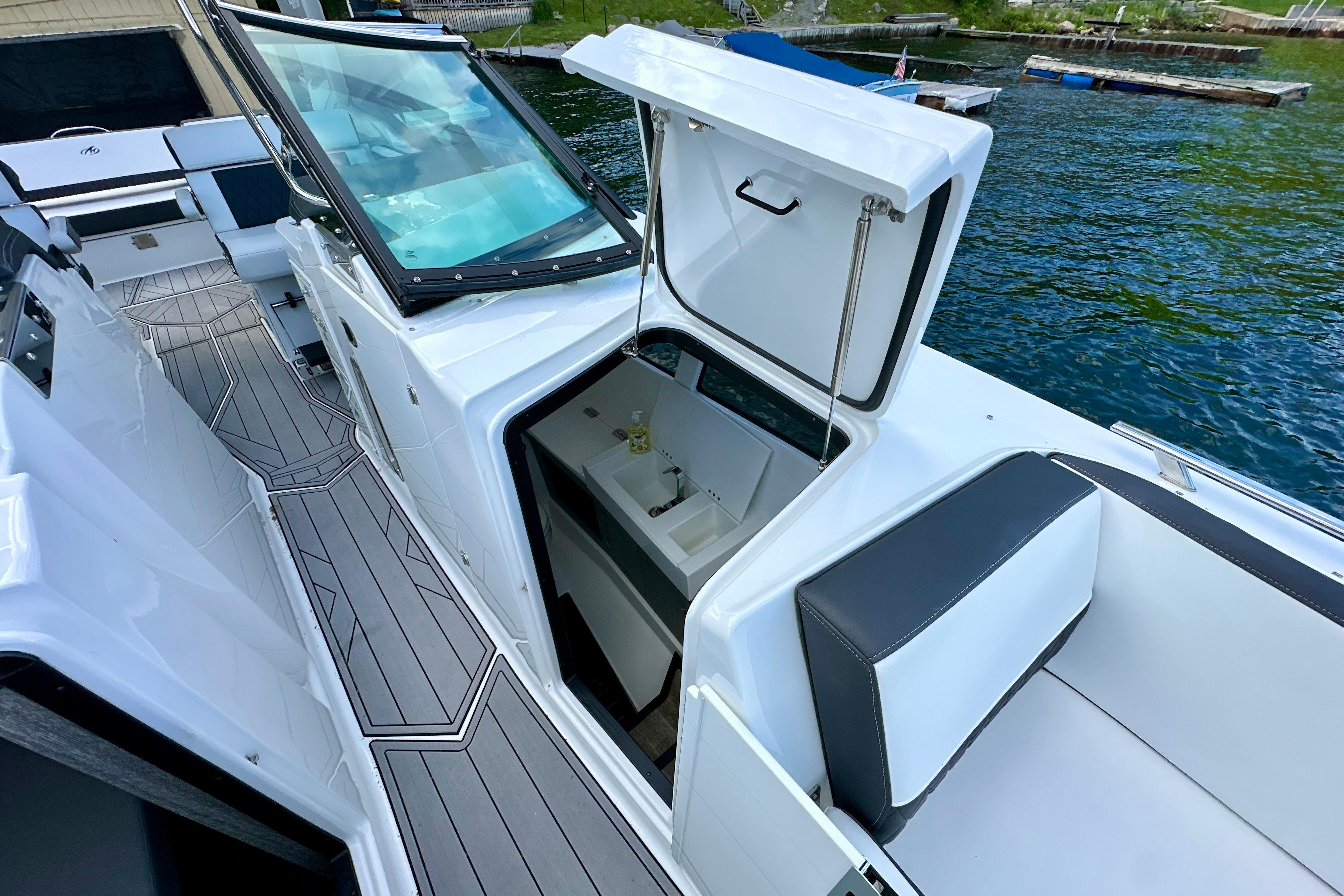 2022 Monterey 378SS Super Sport boat with open storage compartment on deck by the water.