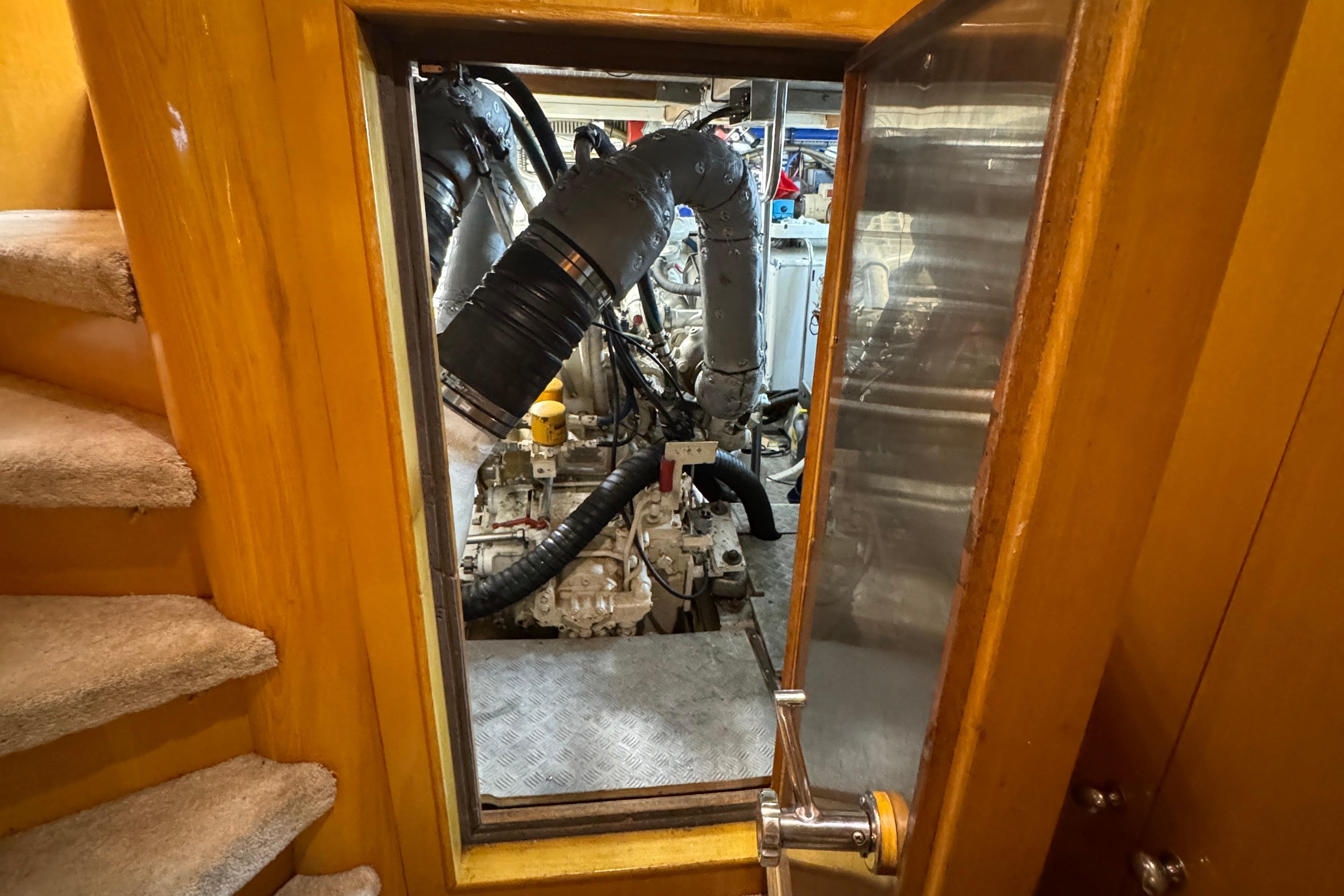 Engine room of a 1994 Johnson High-Tech 65 Euro yacht, viewed through a wooden door.