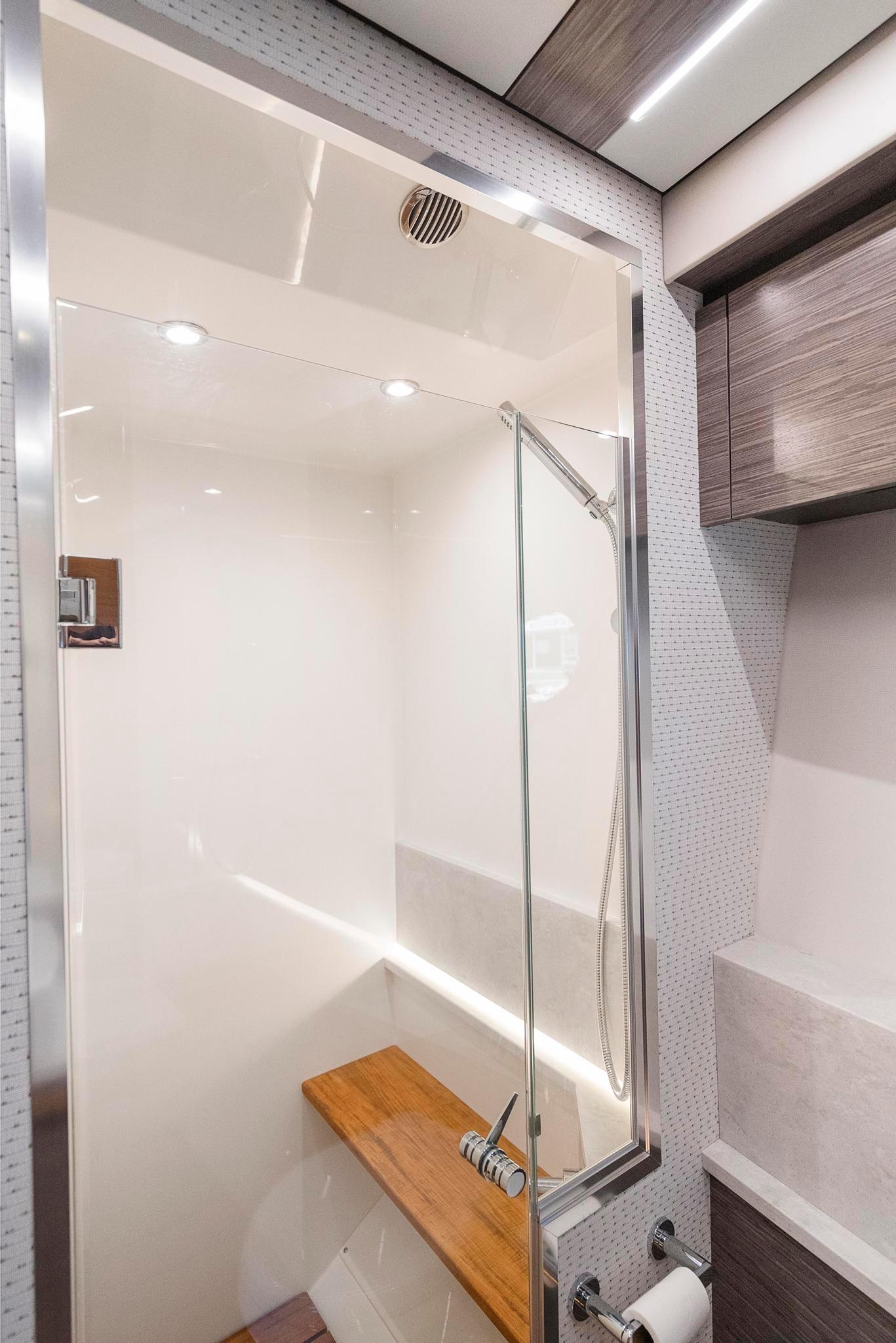 2022 Tiara Yachts C49 Coupe bathroom with modern shower and wooden bench.