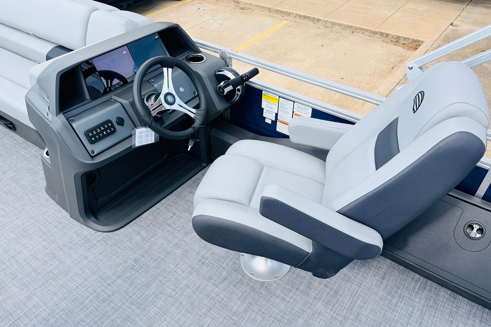 2026 Sun Tracker SportFish 22 DLX boat interior with steering wheel and captain's chair.