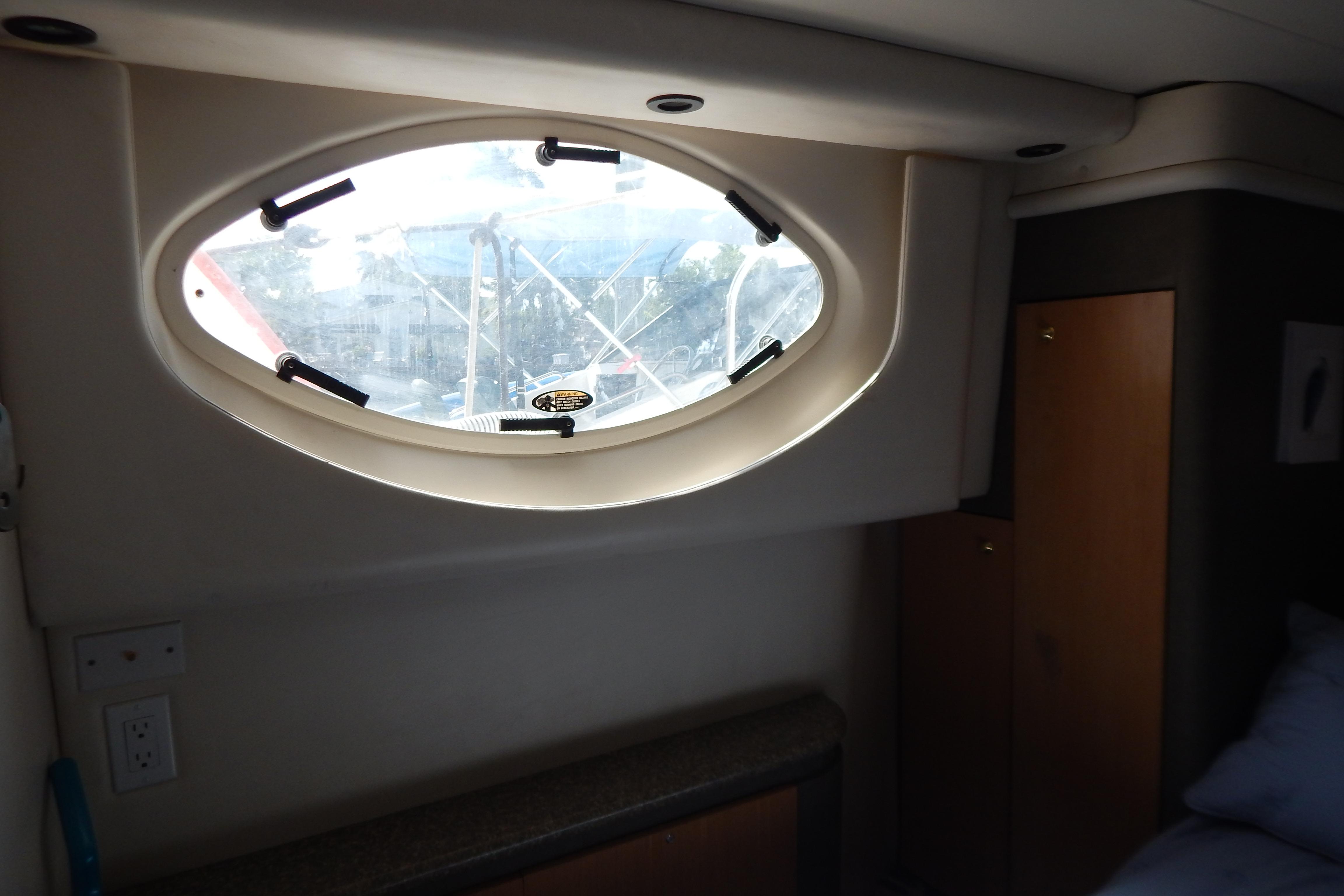 Interior view of 1998 Magnum 4100 SCR yacht with oval window and wooden cabinetry.