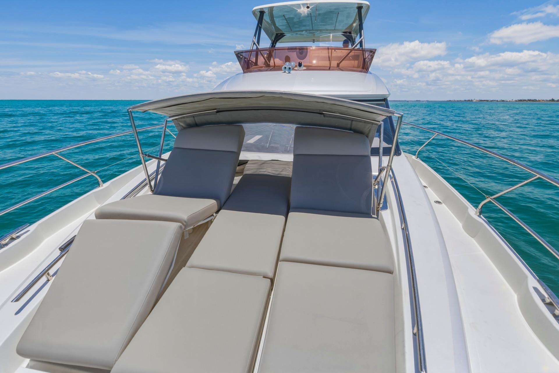 Luxury 2022 Prestige 520 yacht with sun loungers on open sea.