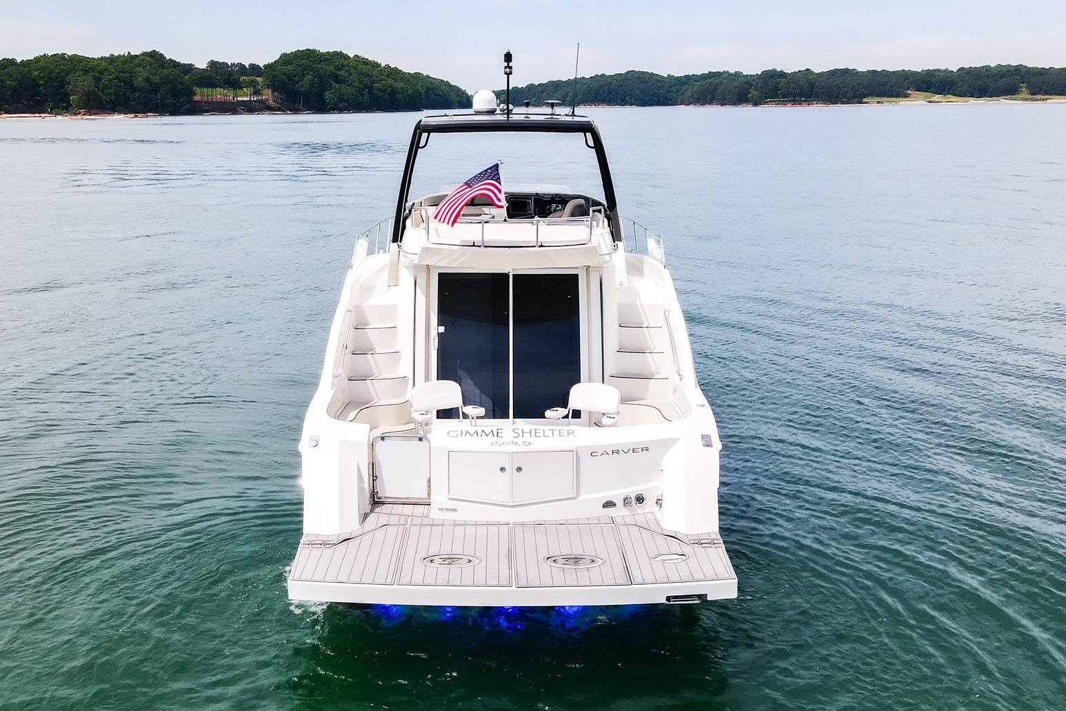 2011 Carver 44 Sojourn yacht on calm water, rear view with American flag.