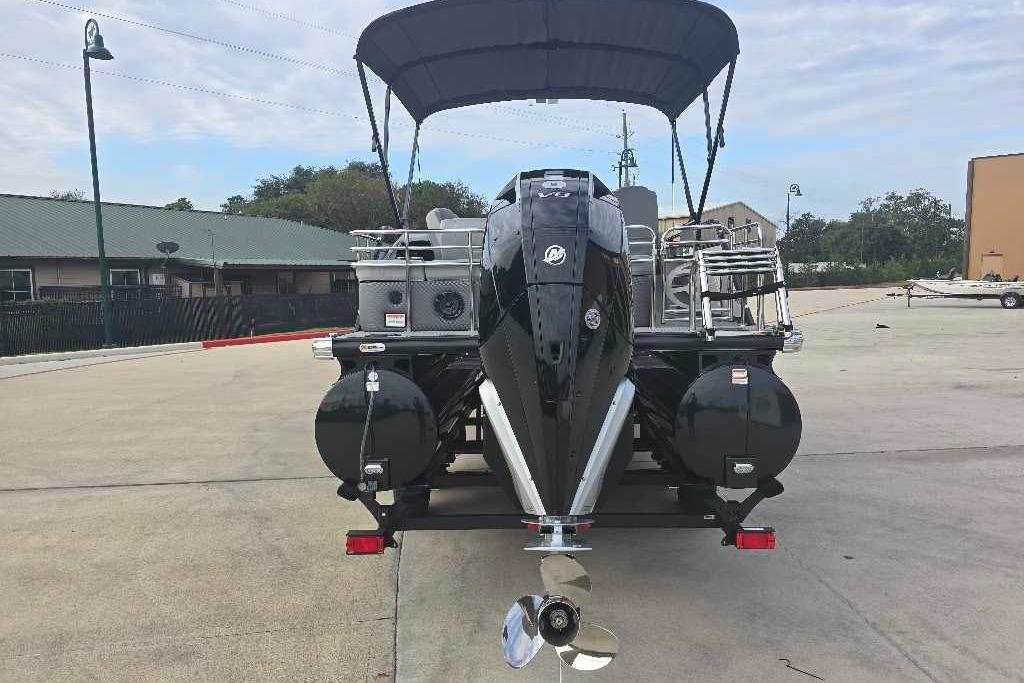 2025 Regency 250 LE3 Sport pontoon boat with canopy, parked on concrete surface.