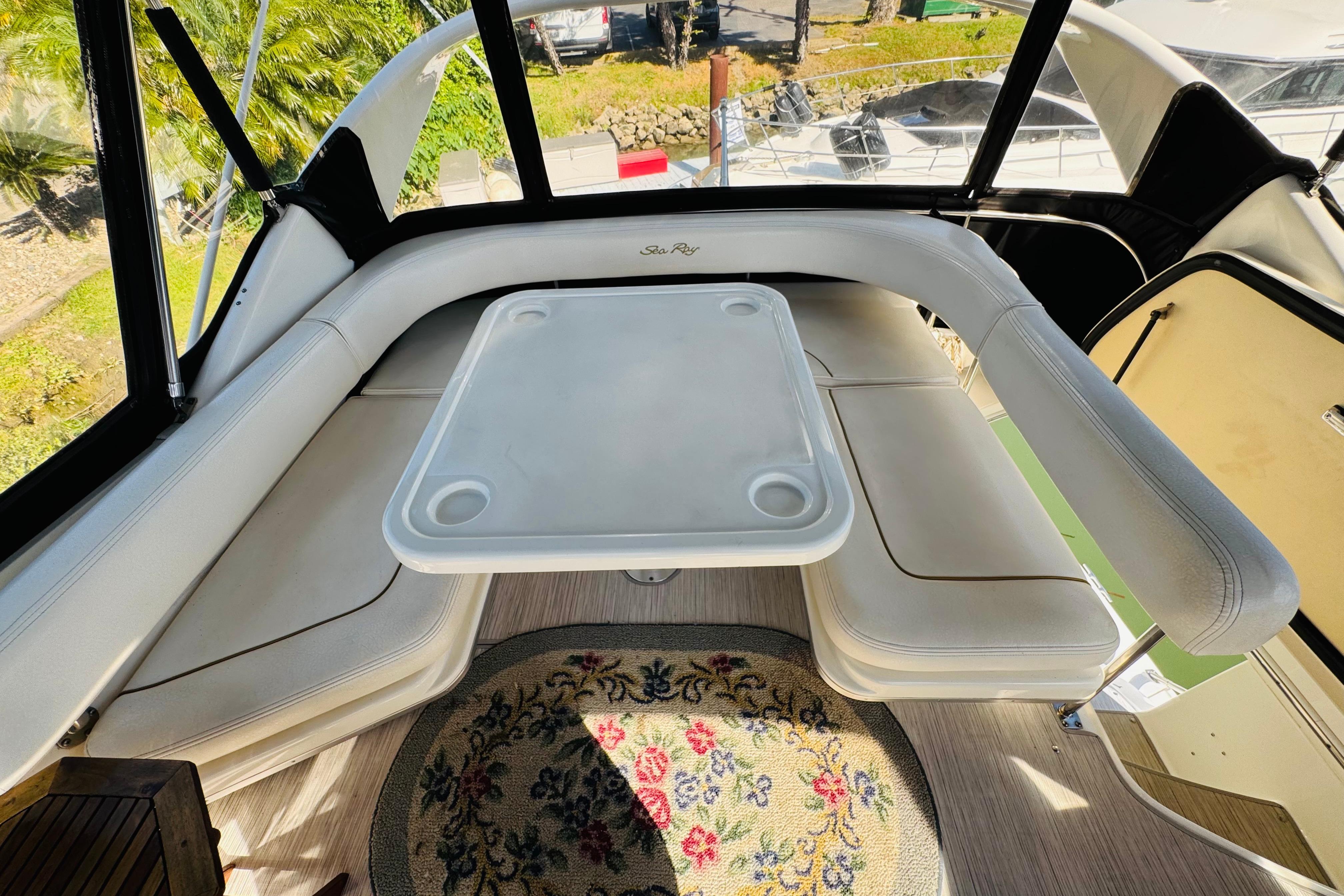 Interior of 2000 Sea Ray 400 Sedan Bridge with white seating and table.