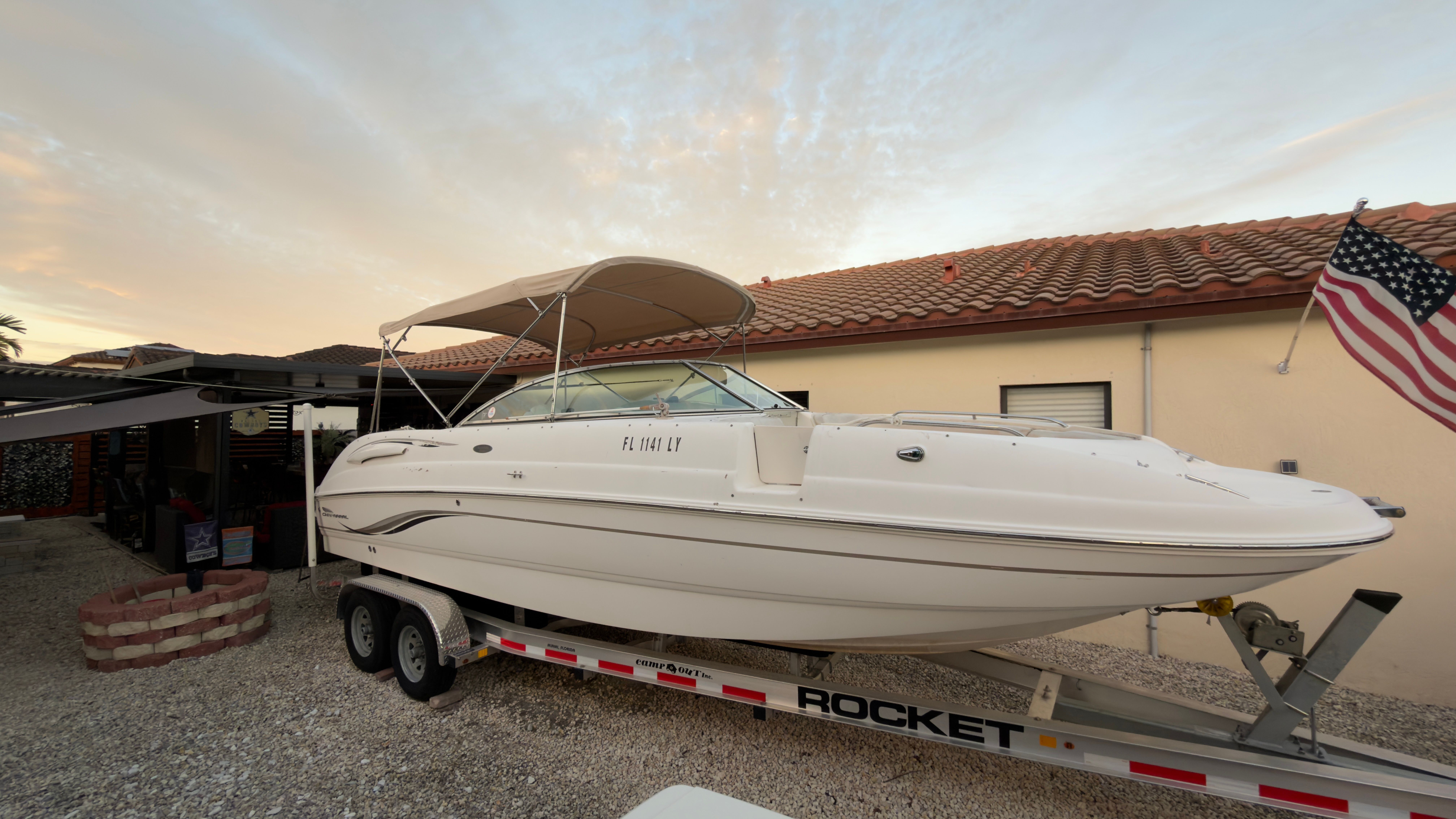 2003 Chaparral 263 Sunesta Deckboat on trailer in front of house.