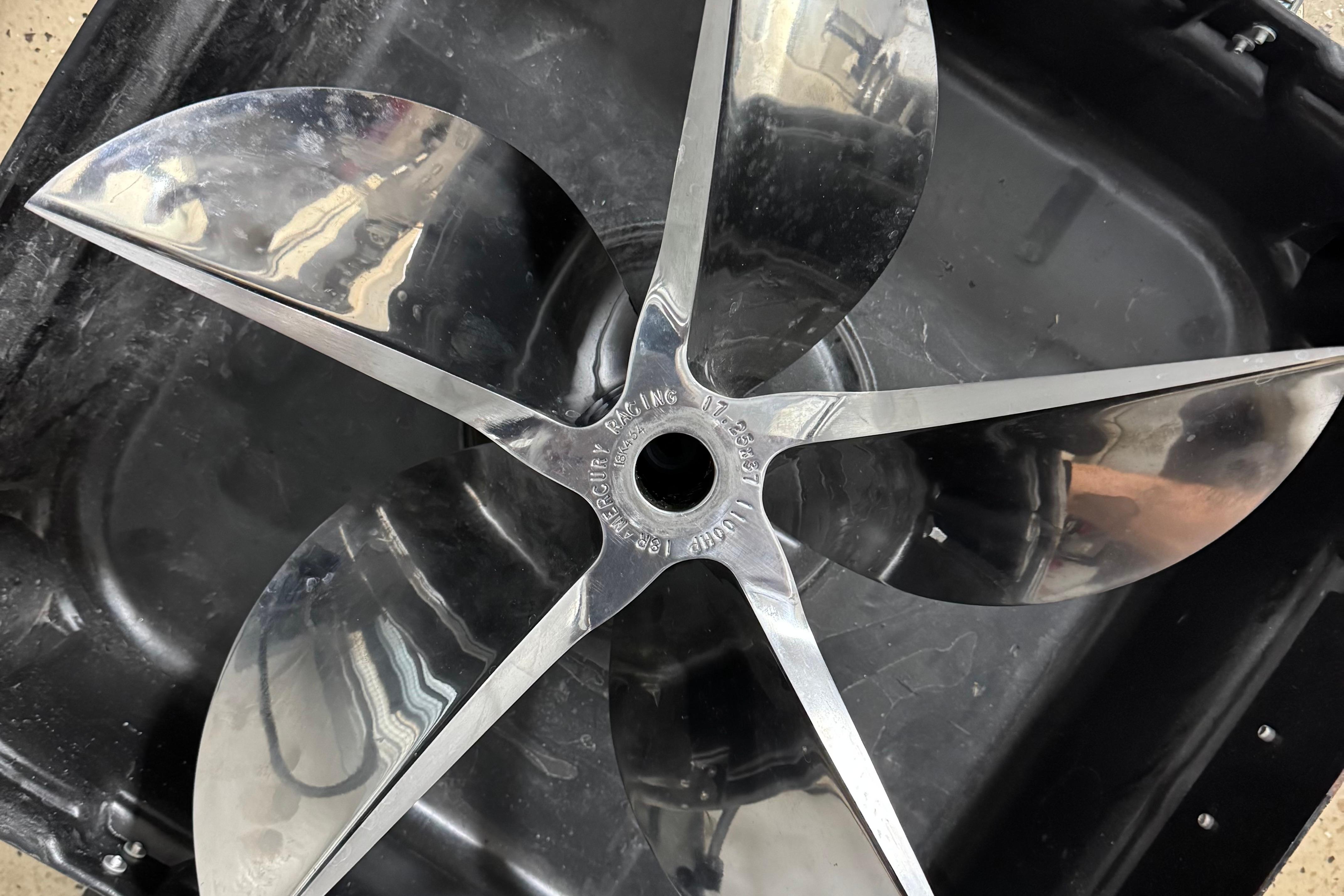 Shiny metal propeller for 2013 Nordic 39 POKER RUN boat, displayed on black surface.