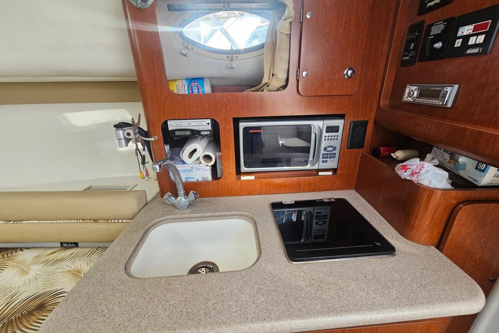 2006 Pro-Line 32 Express boat interior with kitchenette, sink, and microwave.