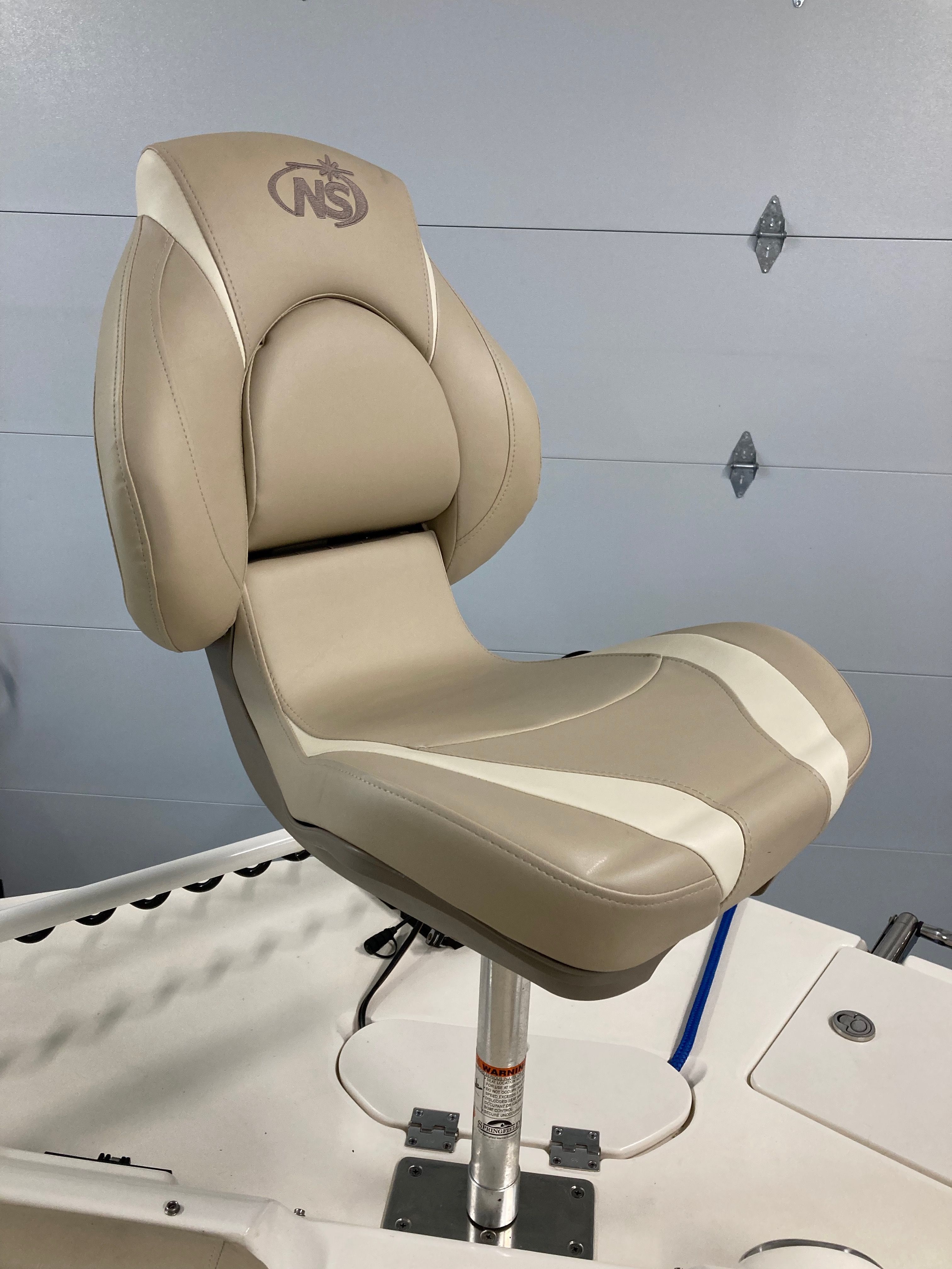 Beige boat seat with padded design and adjustable pedestal.