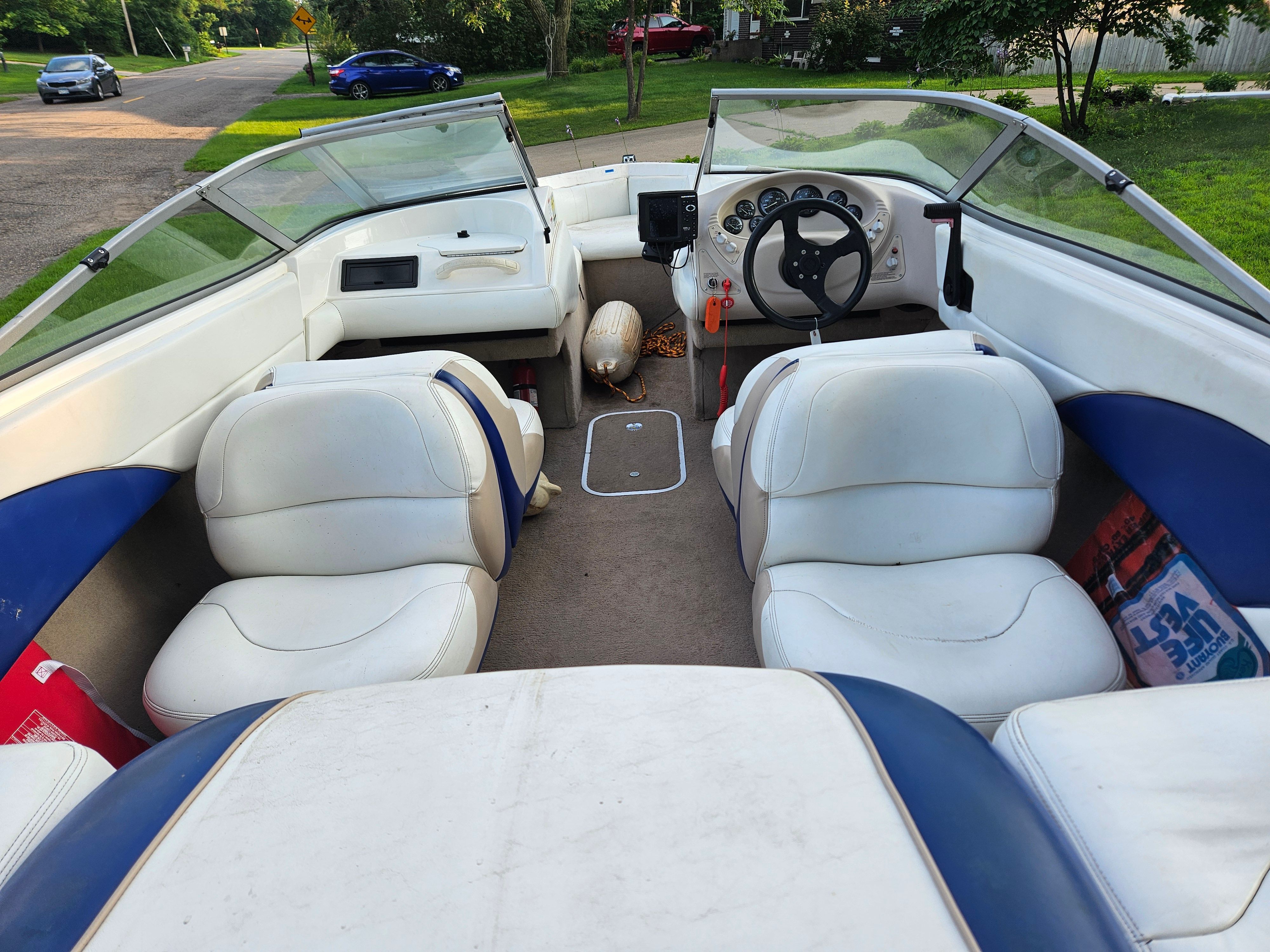 Interior view of a 1996 Wellcraft Excel with white and blue seats, steering wheel, and dashboard.