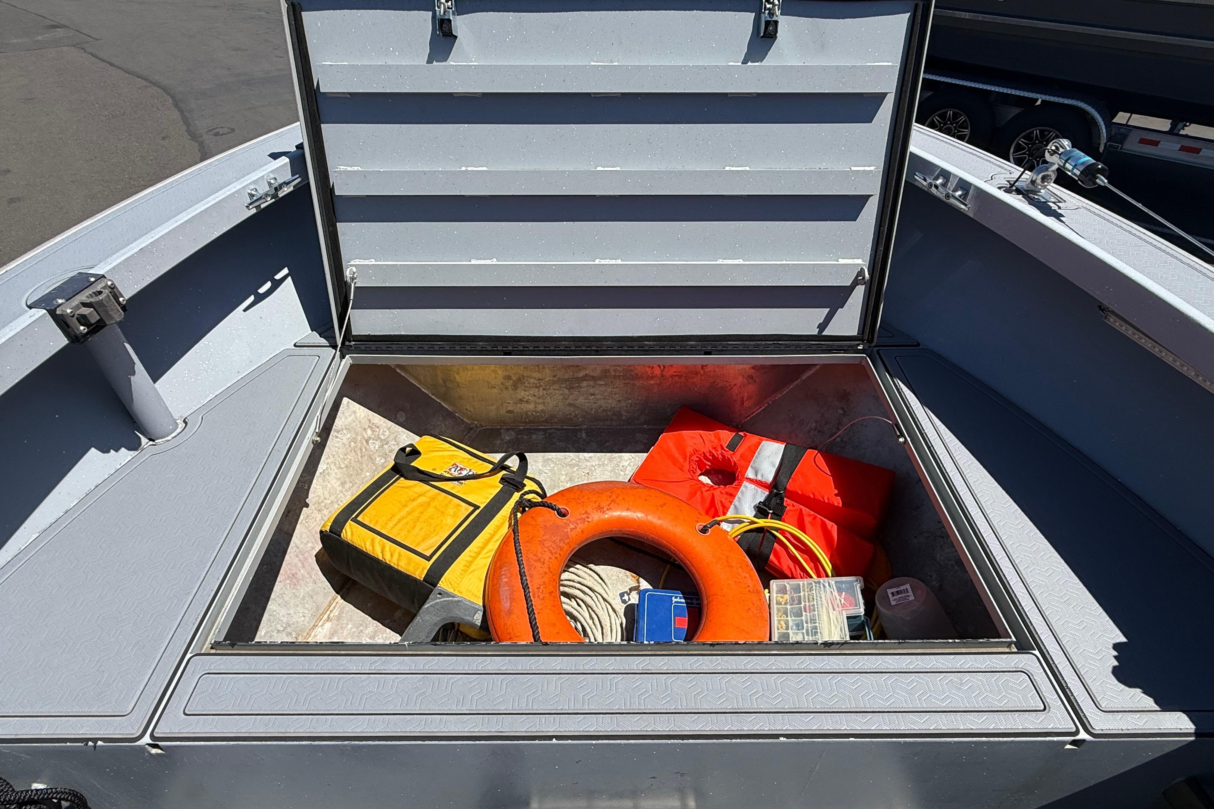 Open storage compartment on 2015 Alumaweld Pacific XD 28 boat with safety gear and equipment.