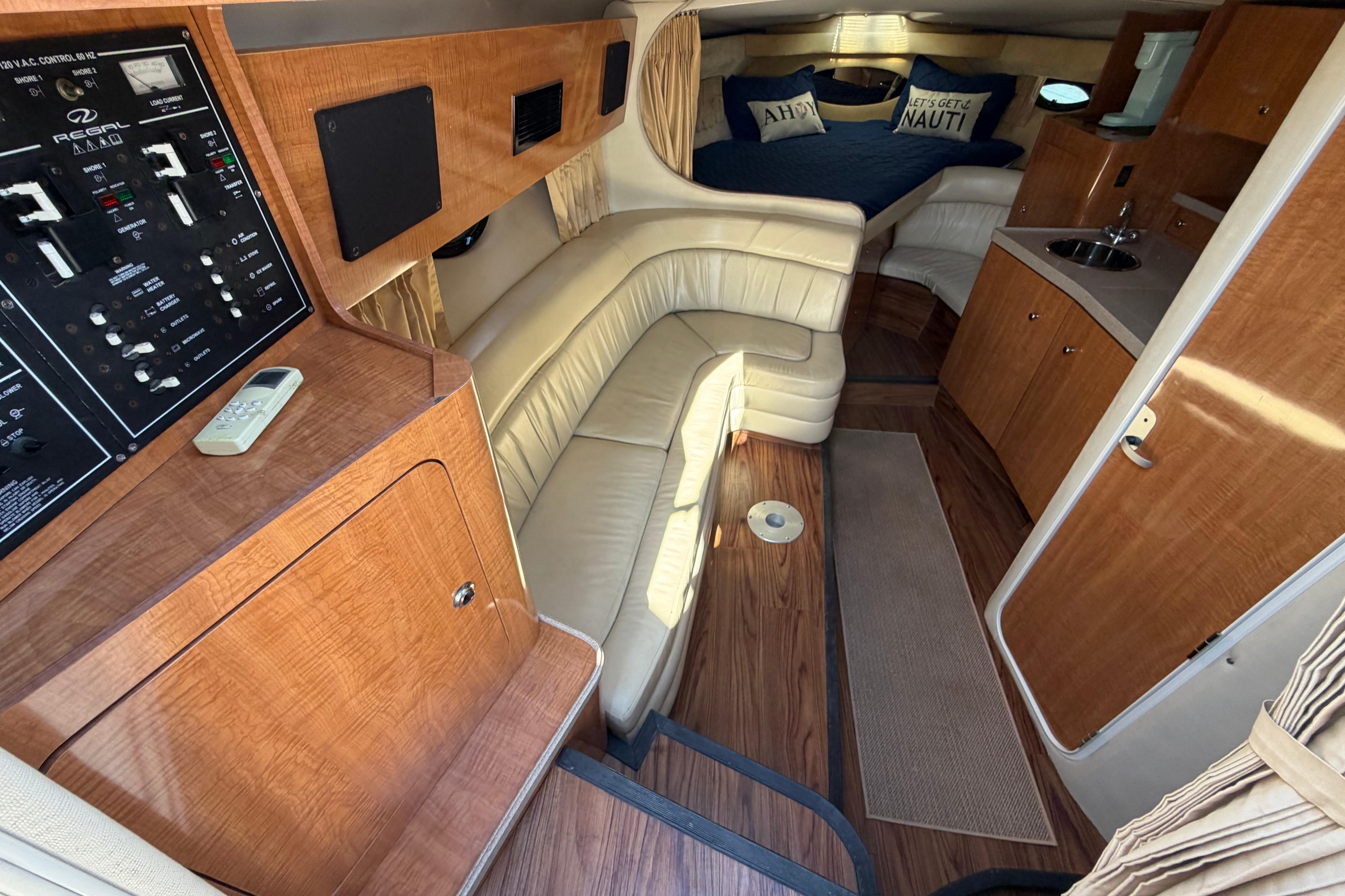 Interior of 2003 Regal Commodore 3260 yacht with plush seating and wood finishes.