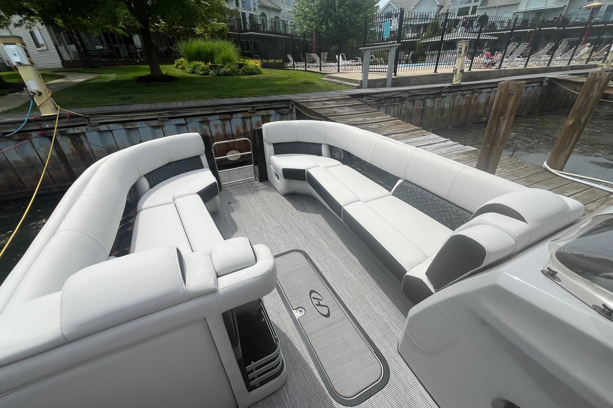 2024 Harris Grand Mariner 250 pontoon boat with luxurious seating at a dock.